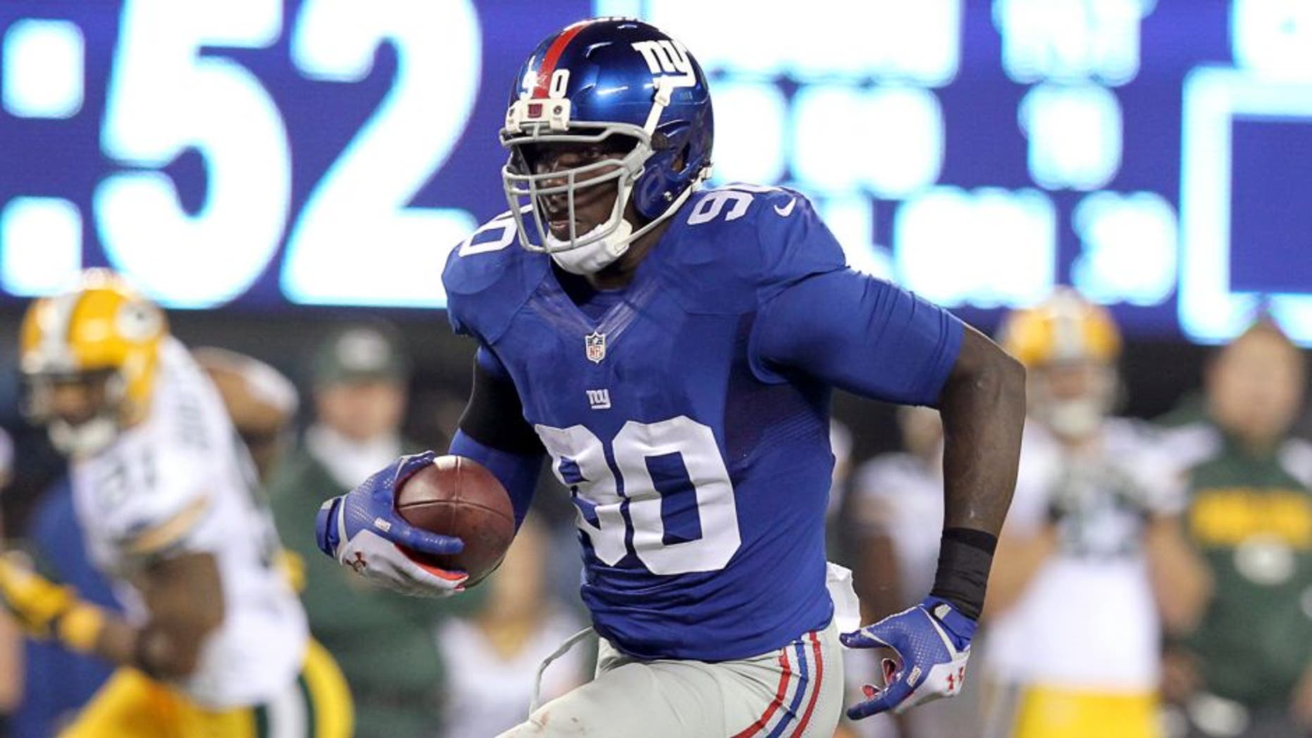 Nov 17, 2013; East Rutherford, NJ, USA; New York Giants defensive end Jason Pierre-Paul (90) runs back an interception against the Green Bay Packers for a touchdown during the fourth quarter of a game at MetLife Stadium. Mandatory Credit: Brad Penner-USA TODAY Sports