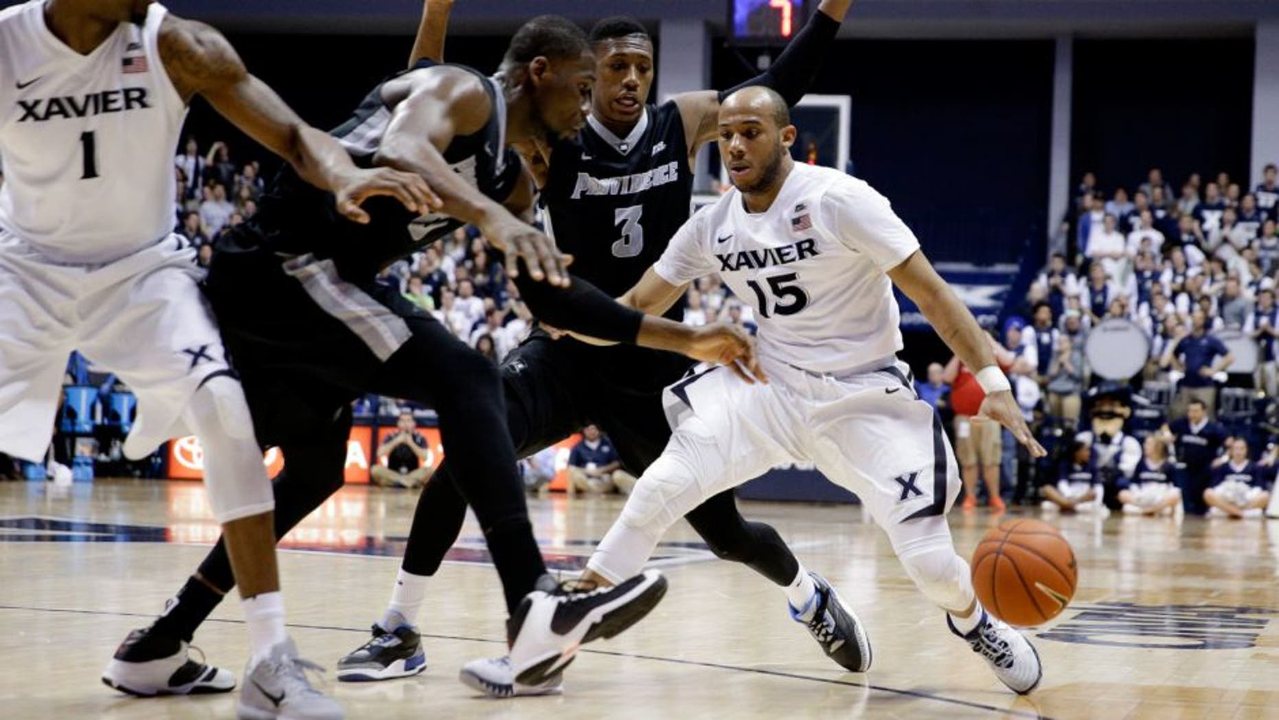 Xavier's Myles Davis (15) drives against Providence's Kris Dunn (3) and Kris Dunn, second from left, during the second half of an NCAA college basketball game Wednesday, Feb. 17, 2016, in Cincinnati. Xavier won 85-74. (AP Photo/John Minchillo)