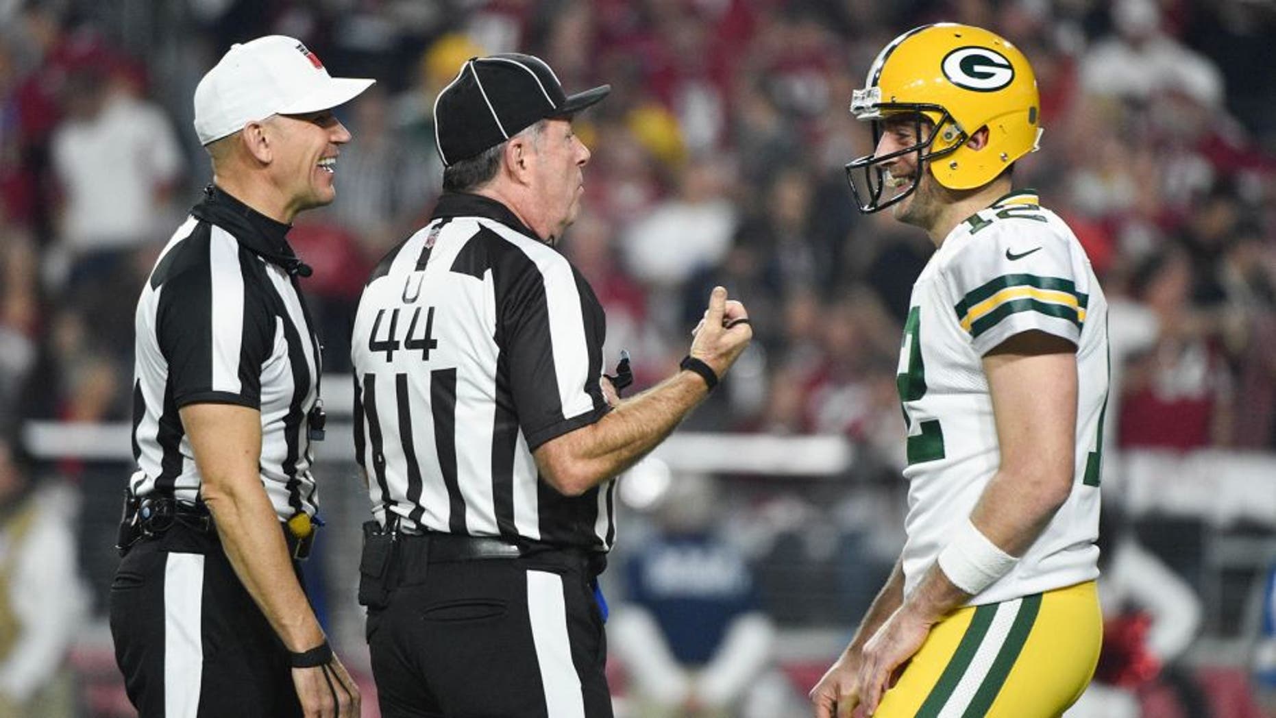 January 16, 2016; Glendale, AZ, USA; Green Bay Packers quarterback Aaron Rodgers (12) talks to NFL referee Clete Blakeman (34, left) and umpire Jeff Rice (44) during the first quarter in a NFC Divisional round playoff game against the Arizona Cardinals at University of Phoenix Stadium. The Cardinals defeated the Packers 26-20 in overtime. Mandatory Credit: Kyle Terada-USA TODAY Sports