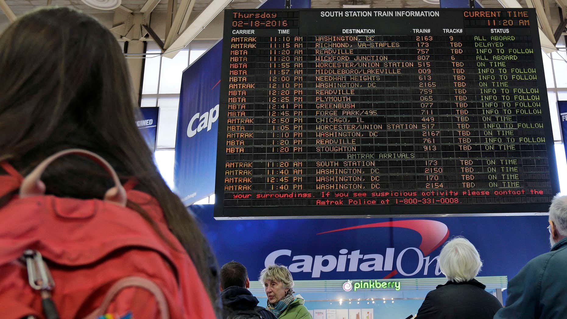 Feb. 18, 2016: With many delays and cancelations posted, travelers watch the train departure board at South Station in Boston.