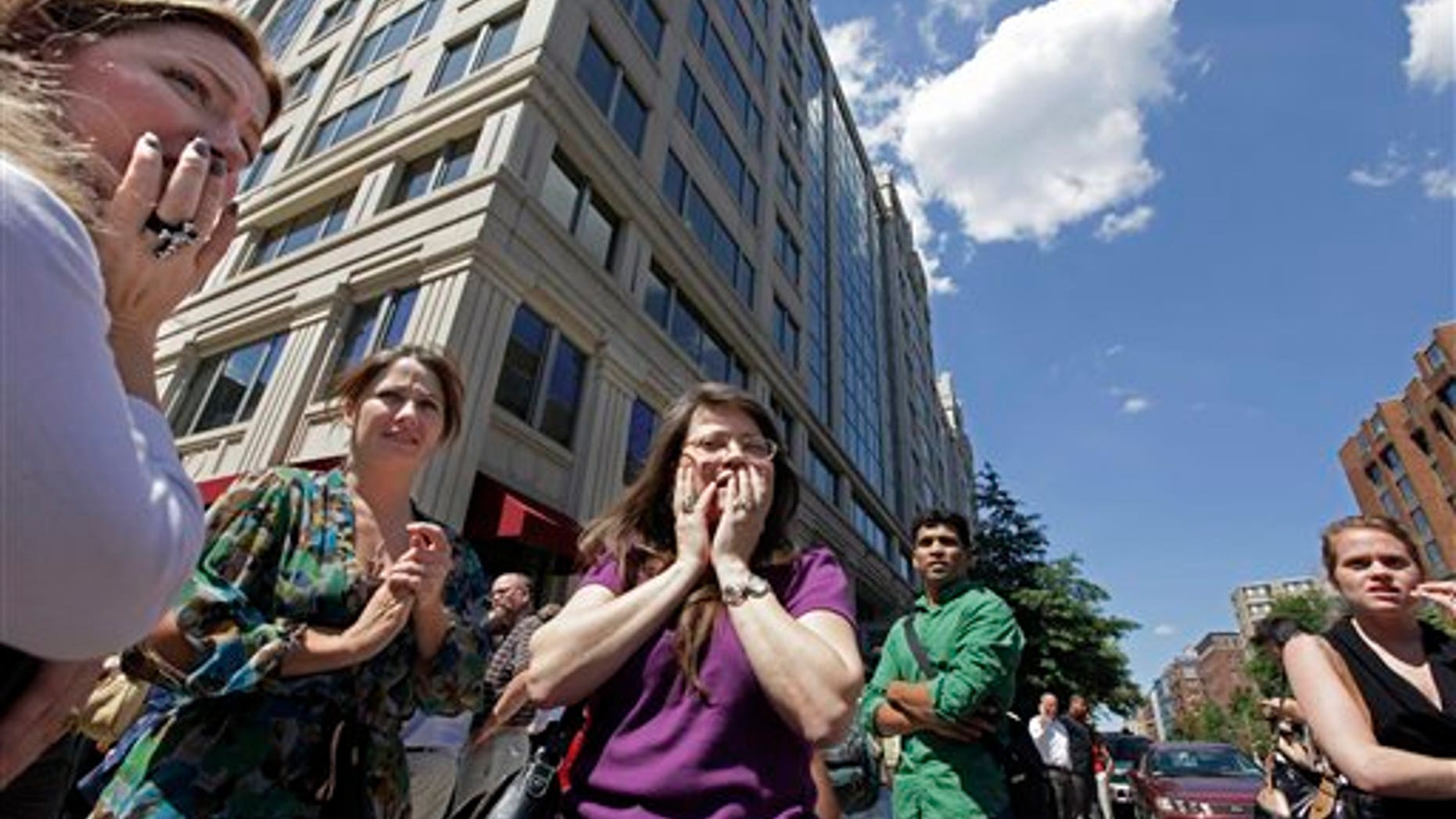 FILE - This Aug. 23, 2011 file photo shows office workers gathering on the sidewalk in downtown Washington after a 5.9 magnitude tremor shook the nation's capitol. The earthquake centered northwest of Richmond, Va., shook much of Washington, D.C., and was felt as far north as Rhode Island and New York City. A new federal earthquake risk map dials up the shaking hazard just a bit for about half of the United States and lowers it for nearly a quarter of the nation. The U.S. Geologic Survey updated Thursday its national seismic hazard maps for the first time since 2008, taking into account research from the devastating 2011 earthquake and tsunami off the Japanese coast and the surprise 2011 Virginia temblor. (AP Photo/J. Scott Applewhite, File)
