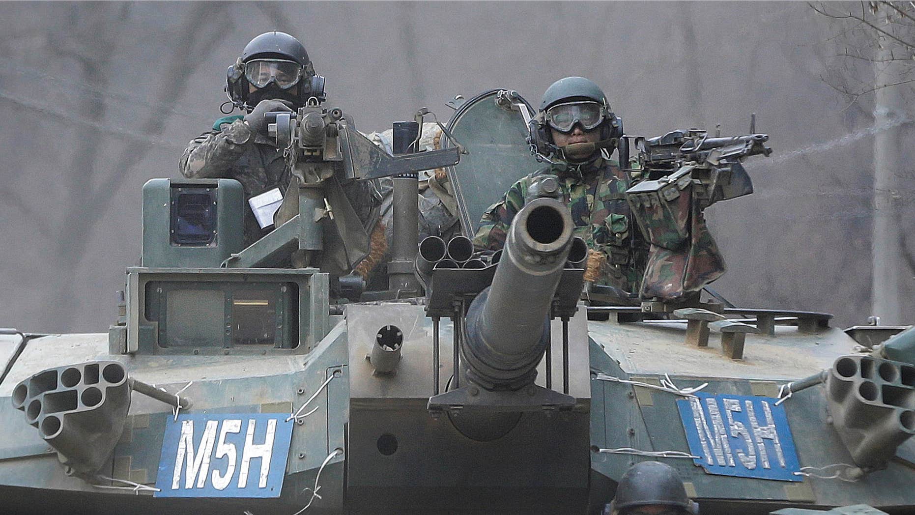 FEb. 19, 2016: South Korean army soldiers ride a K-1 tank during the annual exercise in Paju, near the border with North Korea.