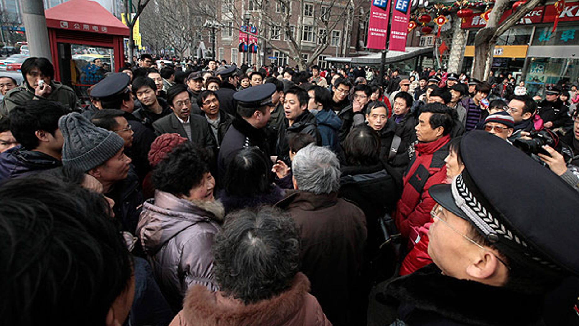 Feb. 20: Police officers urge people to leave as they gather in front of a cinema that was a planned protest site in Shanghai, China.