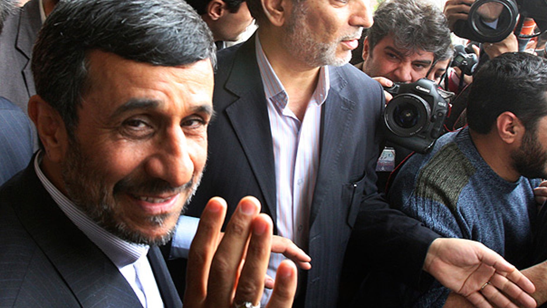 Feb. 20: Iranian President Mahmoud Ahmadinejad waves to the media as he leaves the parliament in Tehran.