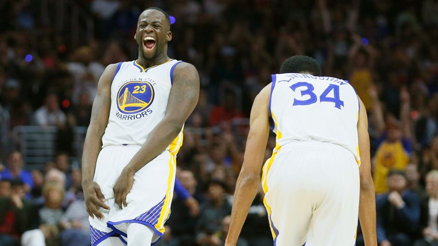Golden State Warriors' Draymond Green, left, and Shaun Livingston, right, celebrate a 3-pointer by teammate Harrison Barnes, not seen, during the second half of an NBA basketball game against the Los Angeles Clippers, Saturday, Feb. 20, 2016, in Los Angeles. The Warriors won 115-112. (AP Photo/Danny Moloshok)