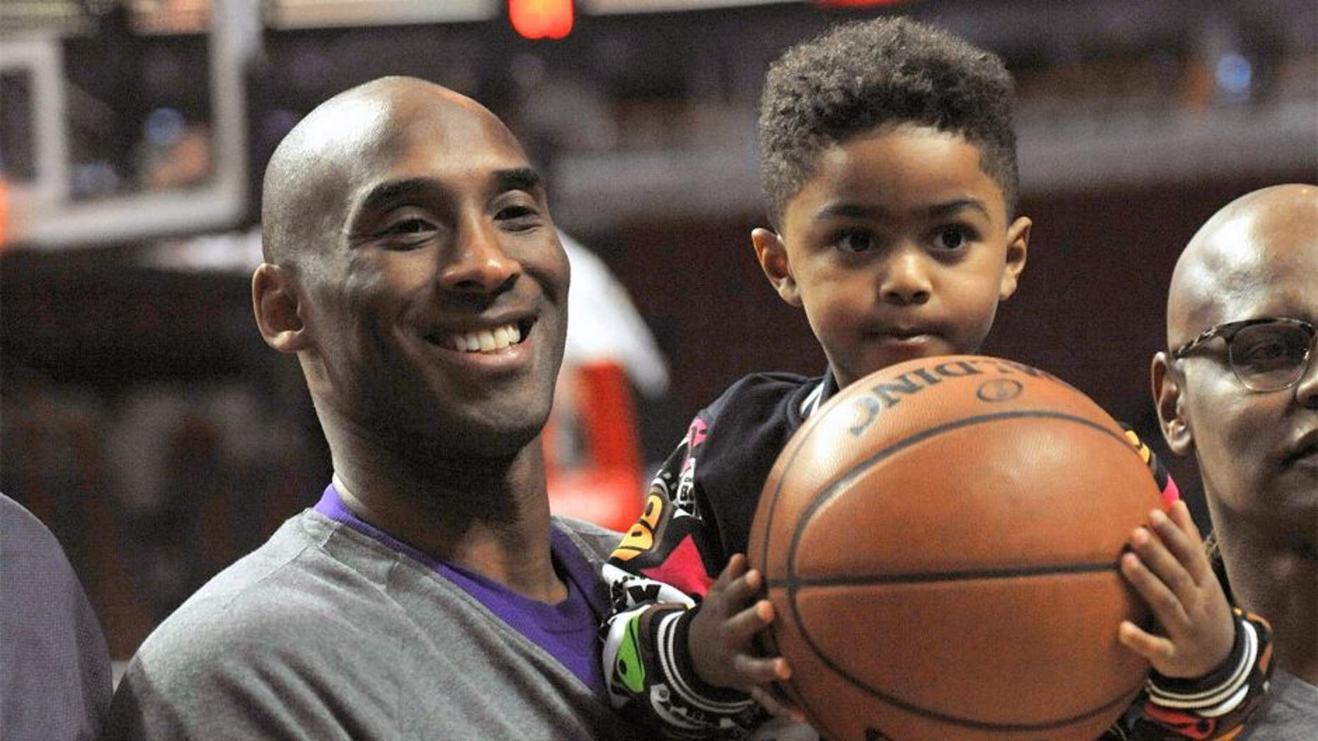 Los Angeles Lakers' Kobe Bryant left, poses with Chicago Bulls' Derrick Rose's son P.J. Rose 3, before an NBA basketball game against the Chicago Bulls, Sunday, Feb. 21, 2016, in Chicago. (AP Photo/Paul Beaty)