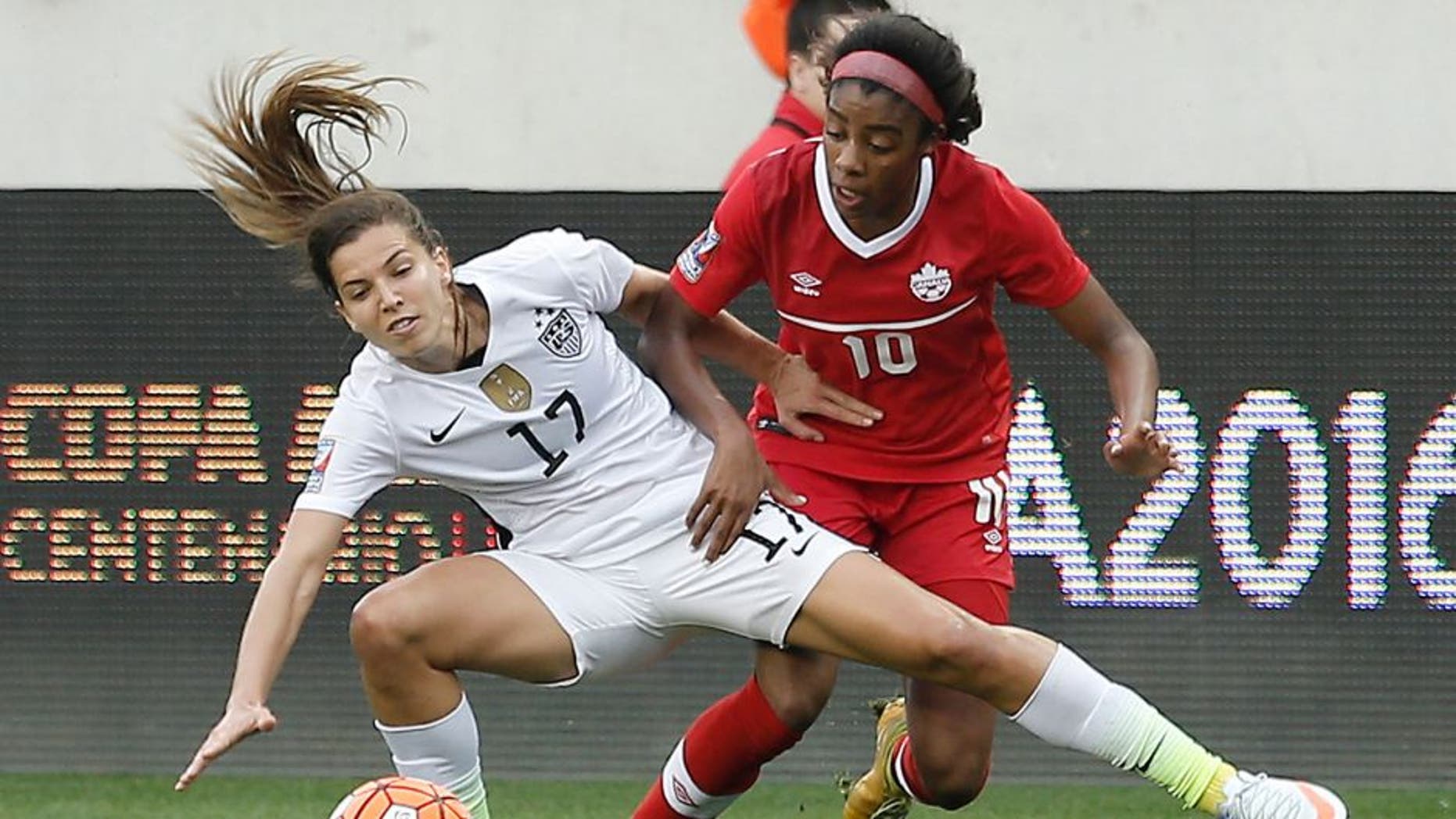 Feb 21, 2016; Houston, TX, USA; USA midfielder Tobin Heath (17) and Canada midfielder Ashley Lawrence (10) fight for possession in the first half during the 2016 CONCACAF women's Olympic soccer tournament at BBVA Compass Stadium. Mandatory Credit: Thomas B. Shea-USA TODAY Sports
