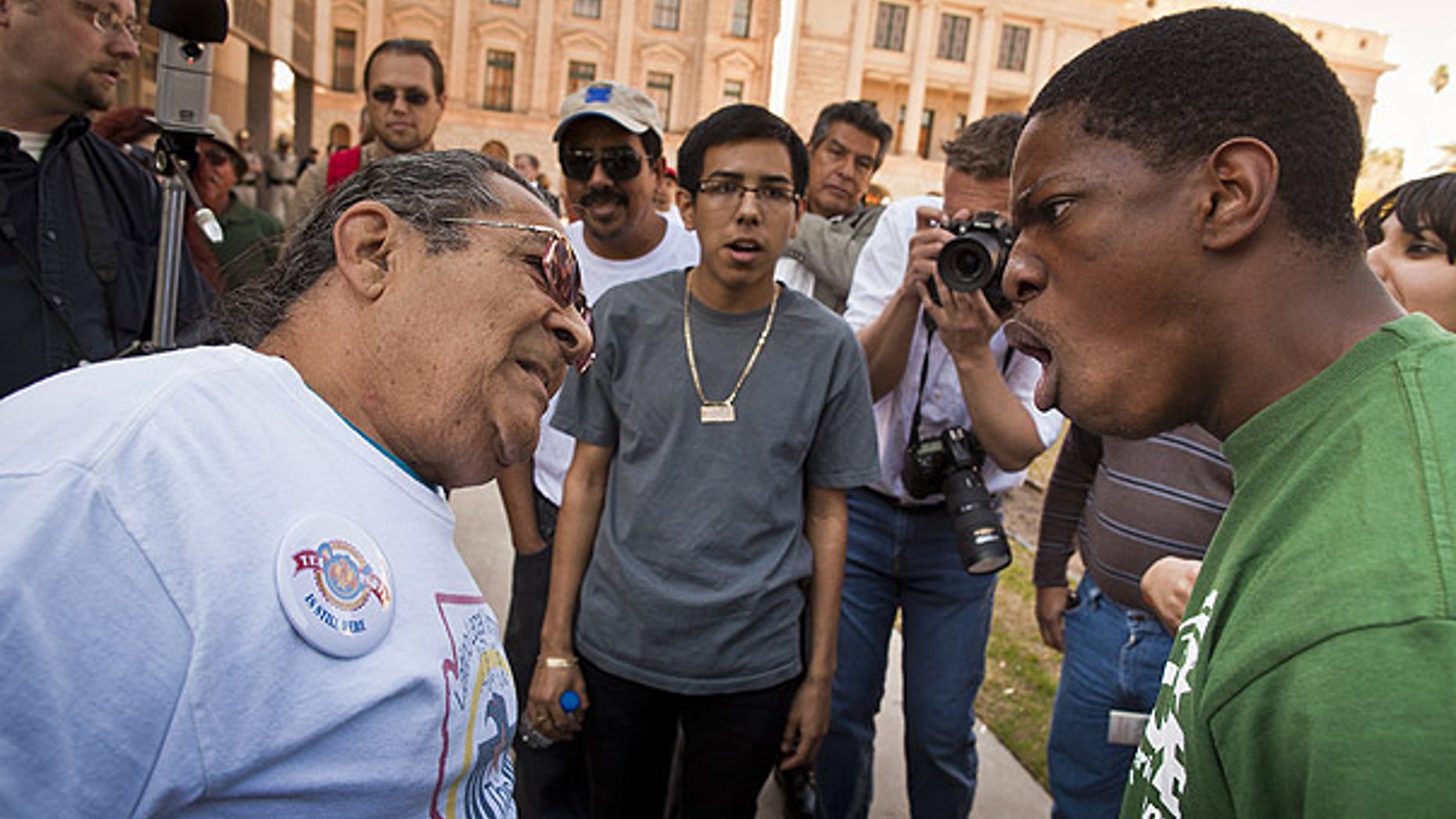 Feb. 22: A supporter and opponent of illegal immigrant birthrights debate at the State Capitol in Phoenix.