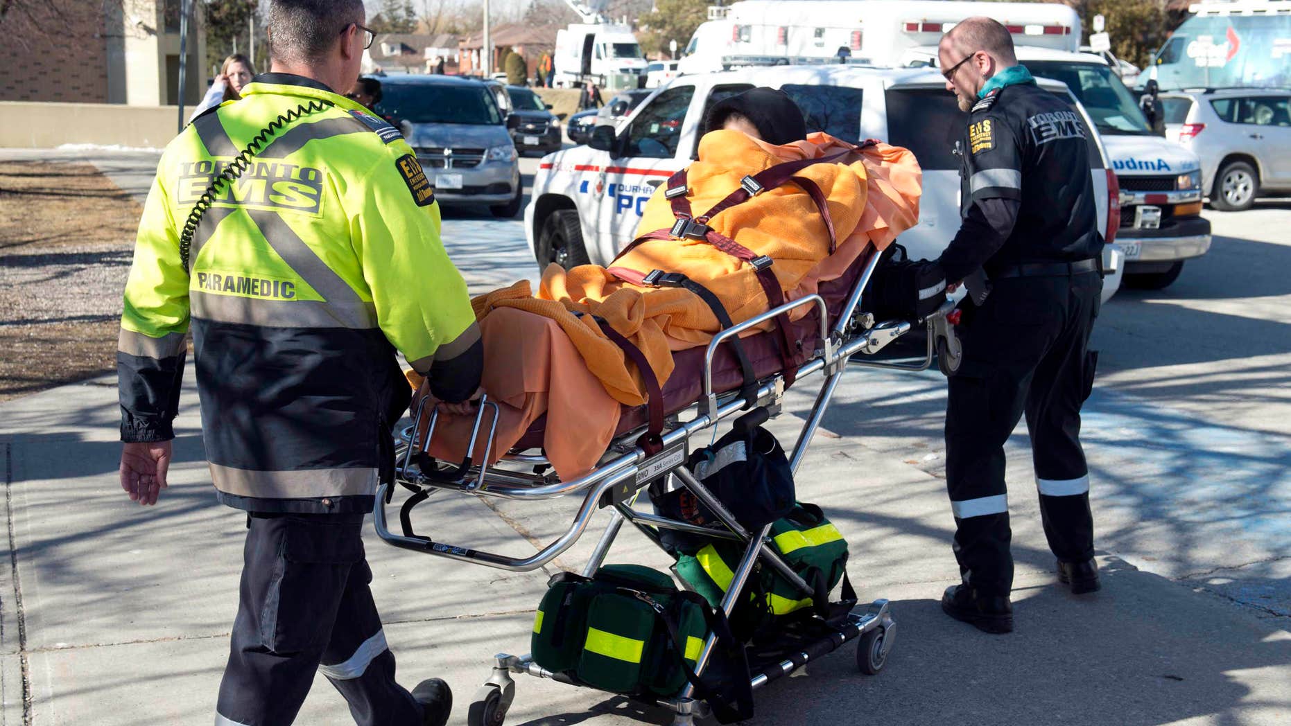 Feb. 24, 2016: An unidentified victim is taken away on a stretcher by emergency personnel remove following a stabbing incident at Dunbarton High School in Pickering, Ontario.
