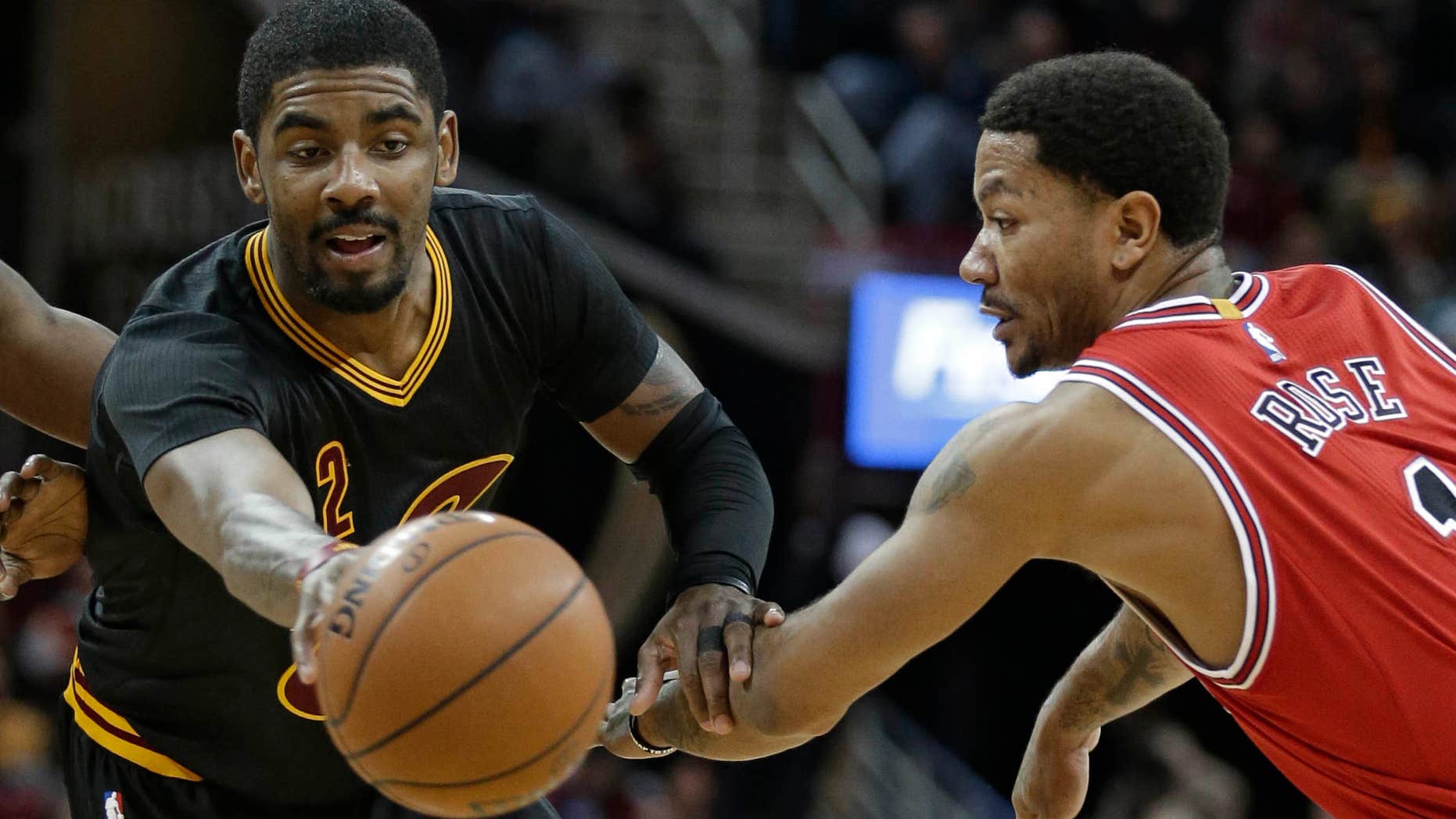 Cleveland Cavaliers' Kyrie Irving, left, passes against Chicago Bulls' Derrick Rose in the second half of an NBA basketball game Thursday, Feb. 18, 2016, in Cleveland.