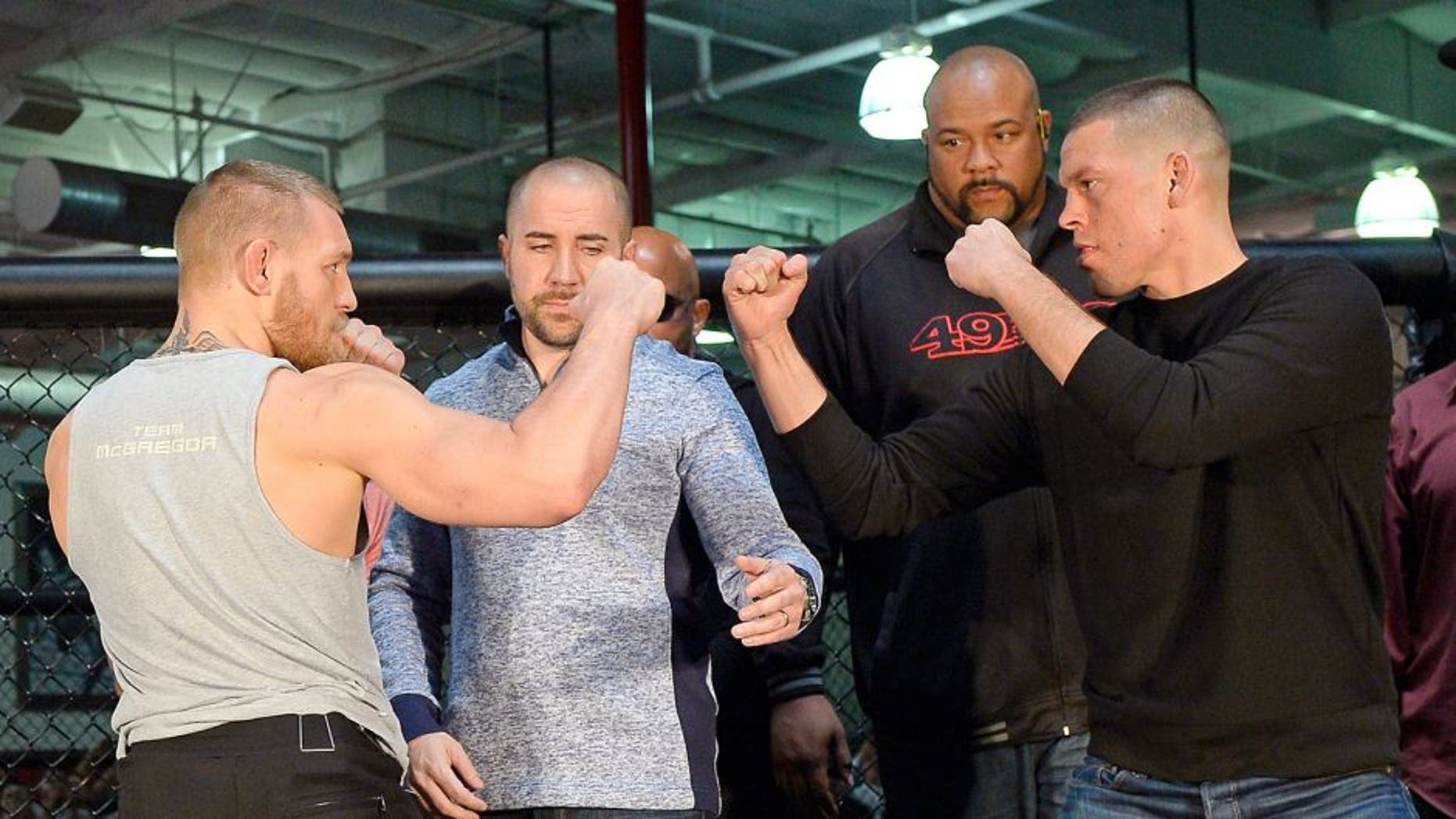 TORRANCE, CA - FEBRUARY 24: UFC featherweight champion Conor McGregor (L) and lightweight contender Nate Diaz (R) are held apart by Dave Sholler (2nd L), UFC vice president of public relations, after a news conference at UFC Gym February 24, 2016, in Torrance, California. (Photo by Kevork Djansezian/Getty Images)
