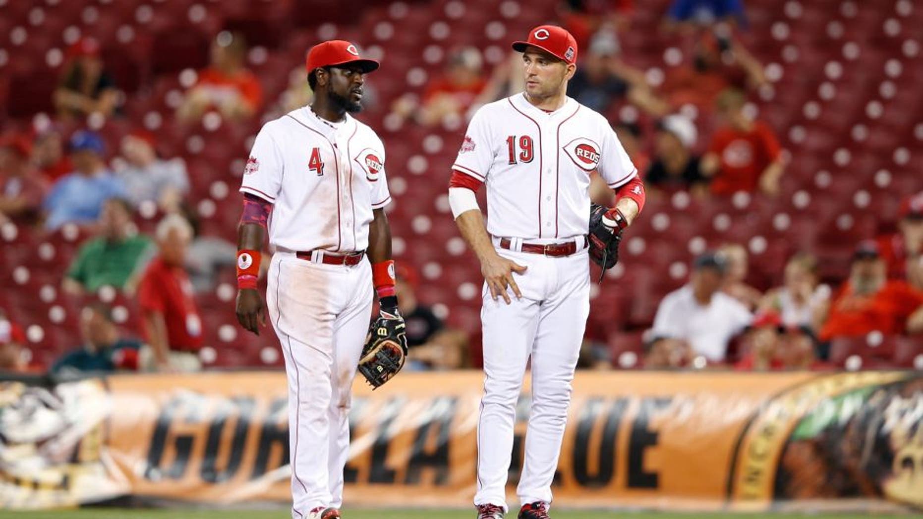 CINCINNATI, OH - AUGUST 18: Joey Votto #19 and Brandon Phillips #4 of the Cincinnati Reds look on against the Kansas City Royals during the game at Great American Ball Park on August 18, 2015 in Cincinnati, Ohio. The Royals defeated the Reds 3-1 in 13 innings. (Photo by Joe Robbins/Getty Images)