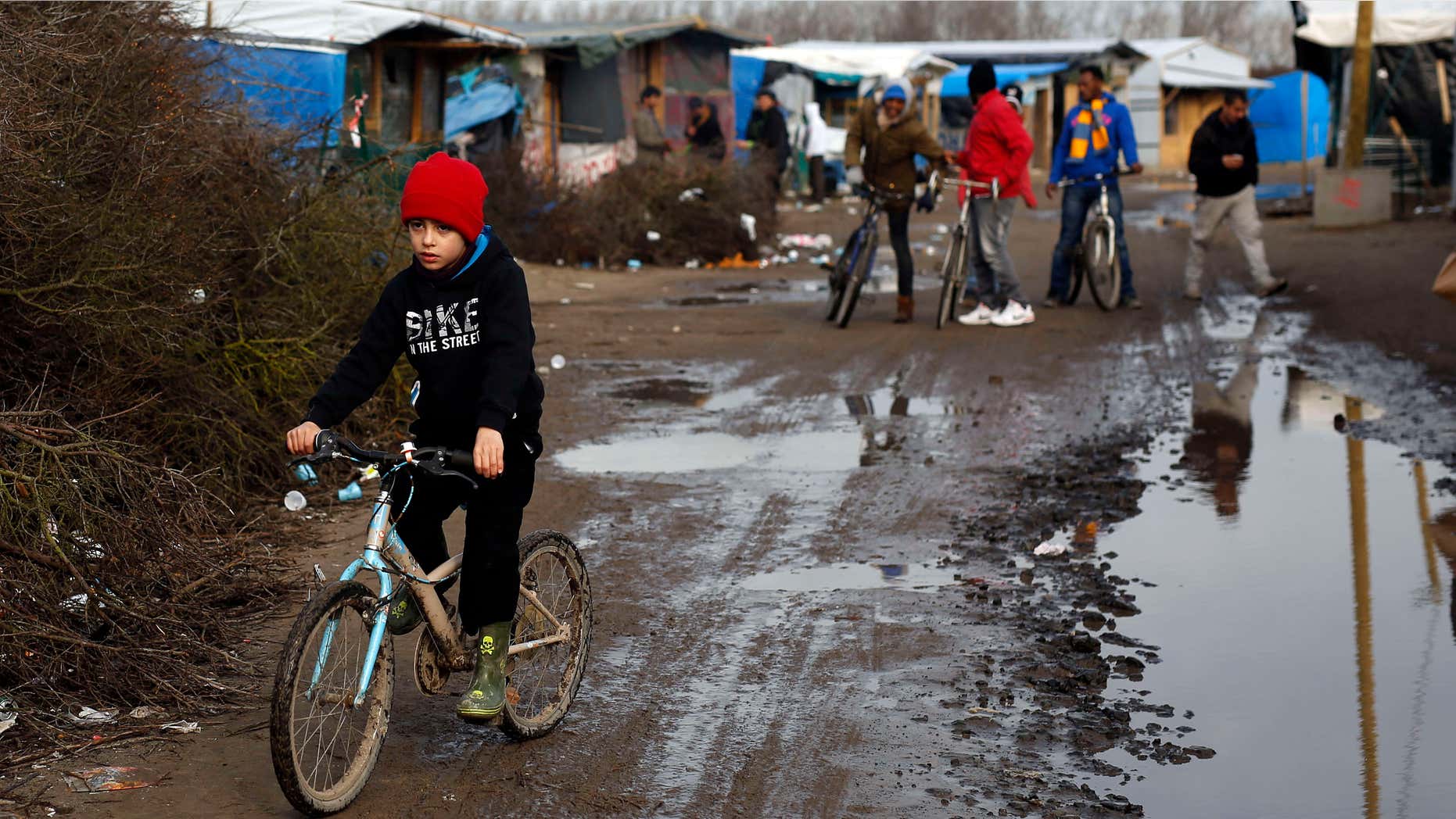 Feb. 25, 2016: A child rides his bicycle in a makeshift camp for migrants near Calais, France.