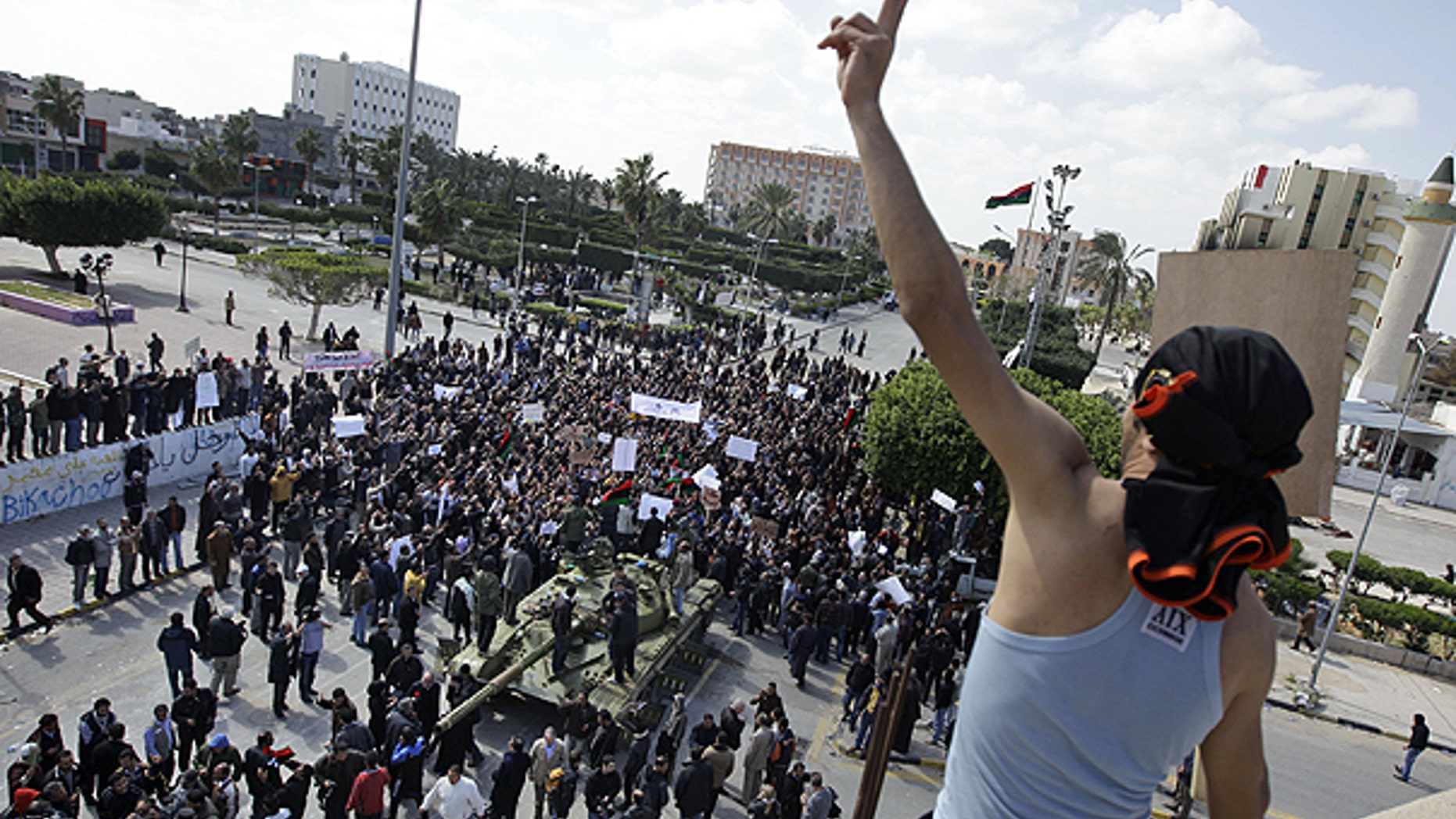 Feb. 27: Residents gather around a tank and an armed man on a rooftop flashes the victory sign, as foreign journalists arrive in Zawiya, 30 miles west of Tripoli, in Libya.