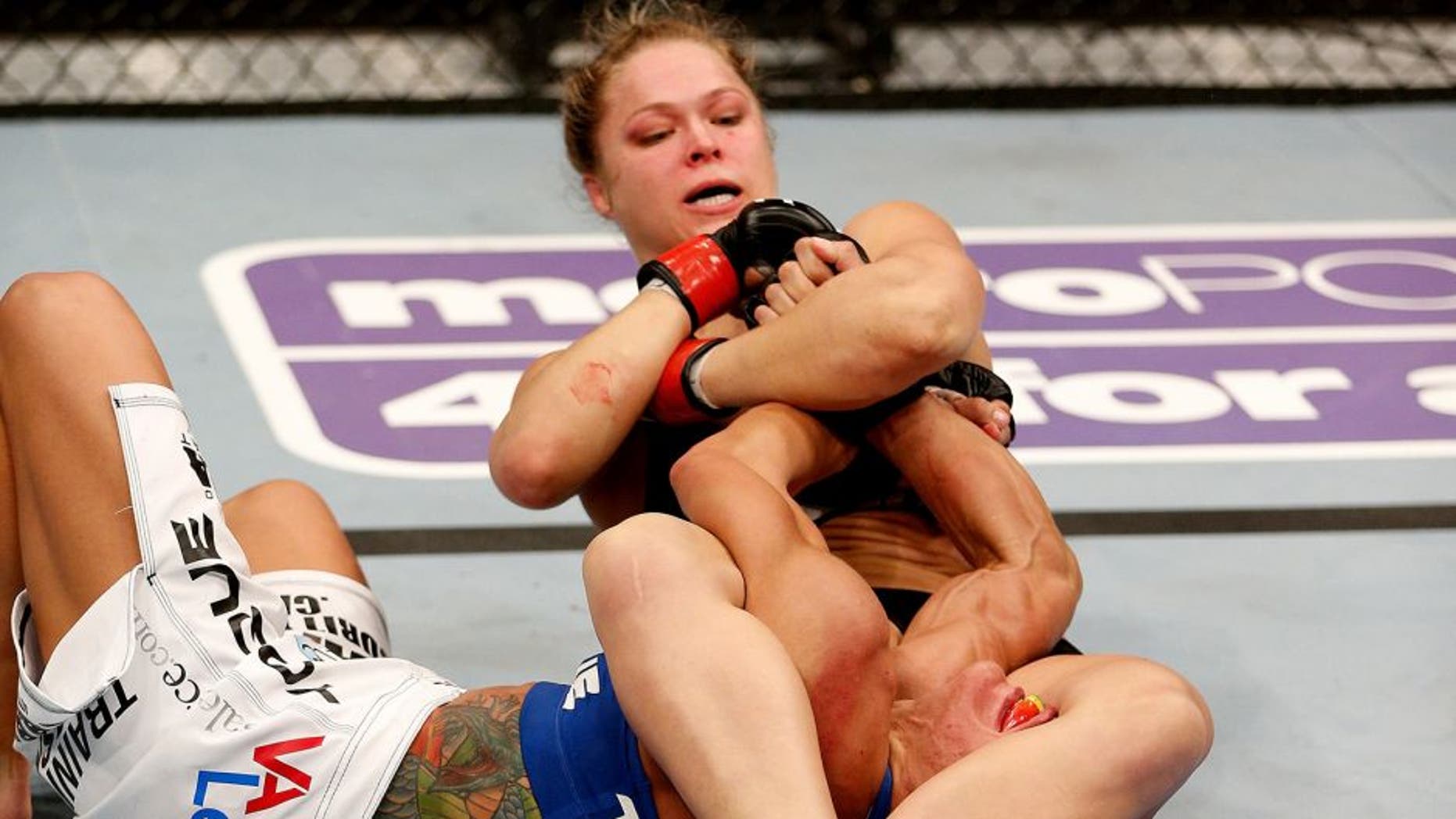 ANAHEIM, CA - FEBRUARY 23: Ronda Rousey (black shorts) secures an arm bar submission against Liz Carmouche in their women's bantamweight title fight during UFC 157 at Honda Center on February 23, 2013 in Anaheim, California. (Photo by Josh Hedges/Zuffa LLC/Zuffa LLC via Getty Images) *** Local Caption *** Ronda Rousey; Liz Carmouche