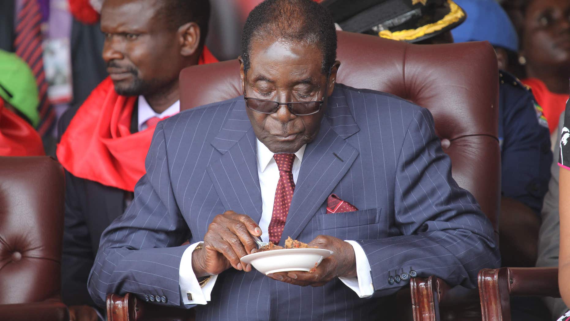FEb. 27, 2016: Zimbabwean President Robert Mugabe eats his cake during celebrations to mark his 92nd Birthday celebrations in Masvingo about 300 kilometres south of Harare,.