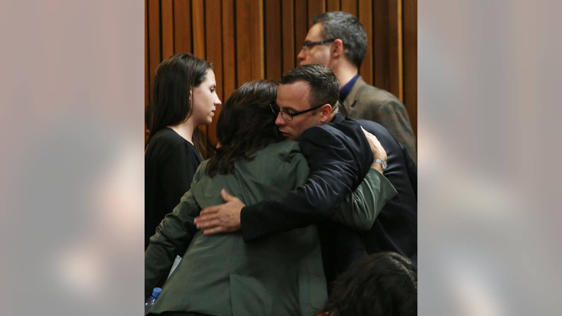 Oscar Pistorius greets and hugs family and friends as the prosecution wraps up its case in Pretoria, South Africa, Tuesday, March 25, 2014. Pistorius is charged with the Valentines Day 2013 shooting death of his girlfriend Reeva Steenkamp. (AP Photo/Esa Alexander, Pool)