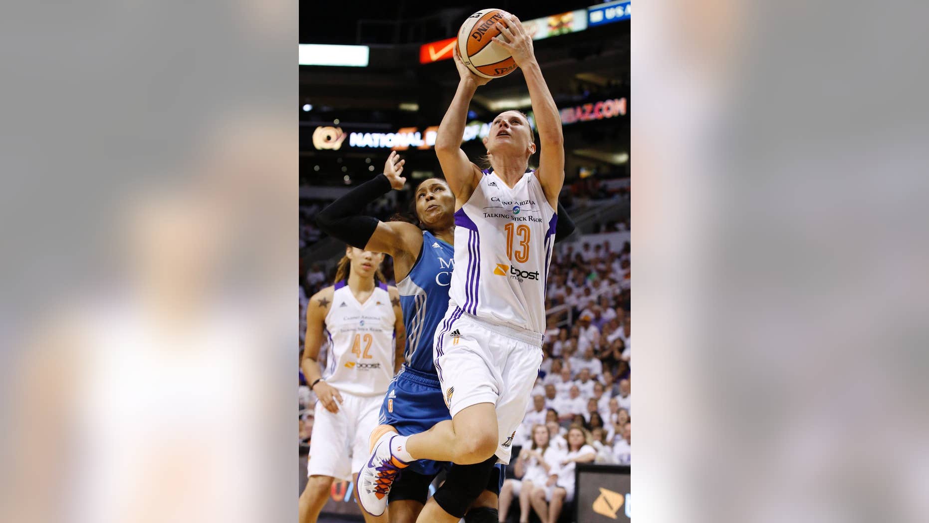 Phoenix Mercury's Penny Taylor (13), of Australia, scores against Minnesota Lynx's Maya Moore, as Mercury's Brittney Griner (42) watches during the second half in Game 1 of the WNBA Western Conference finals Friday, Aug. 29, 2014, in Phoenix. The Mercury defeated the Lynx 85-71. (AP Photo/Ross D. Franklin)