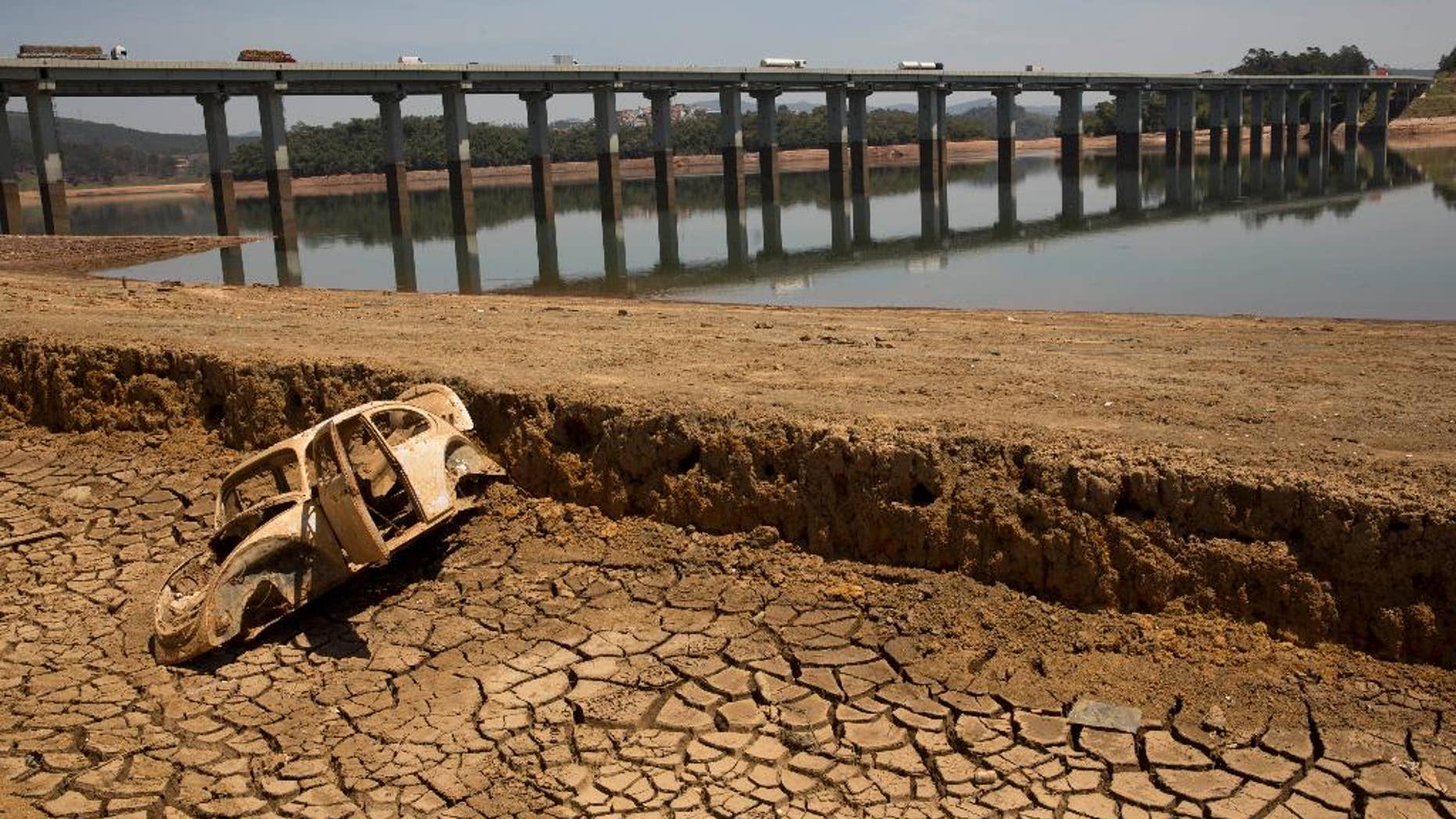 FILE - In this Oct. 10, 2014 file photo, the frame of a car sits on the cracked earth at the bottom of the Atibainha dam, part of the Cantareira System responsible for providing water to the Sao Paulo metropolitan area, in Nazare Paulista, Brazil. Halfway through the rainy season, the key reservoir for the hemisphere's largest city, the Cantareira water system, holds just 6 percent of its capacity, and experts warned Friday, Jan. 16, 2015 that authorities must take urgent steps to prevent the worst drought here in more than 80 years from drying it out. (AP Photo/Andre Penner, File)