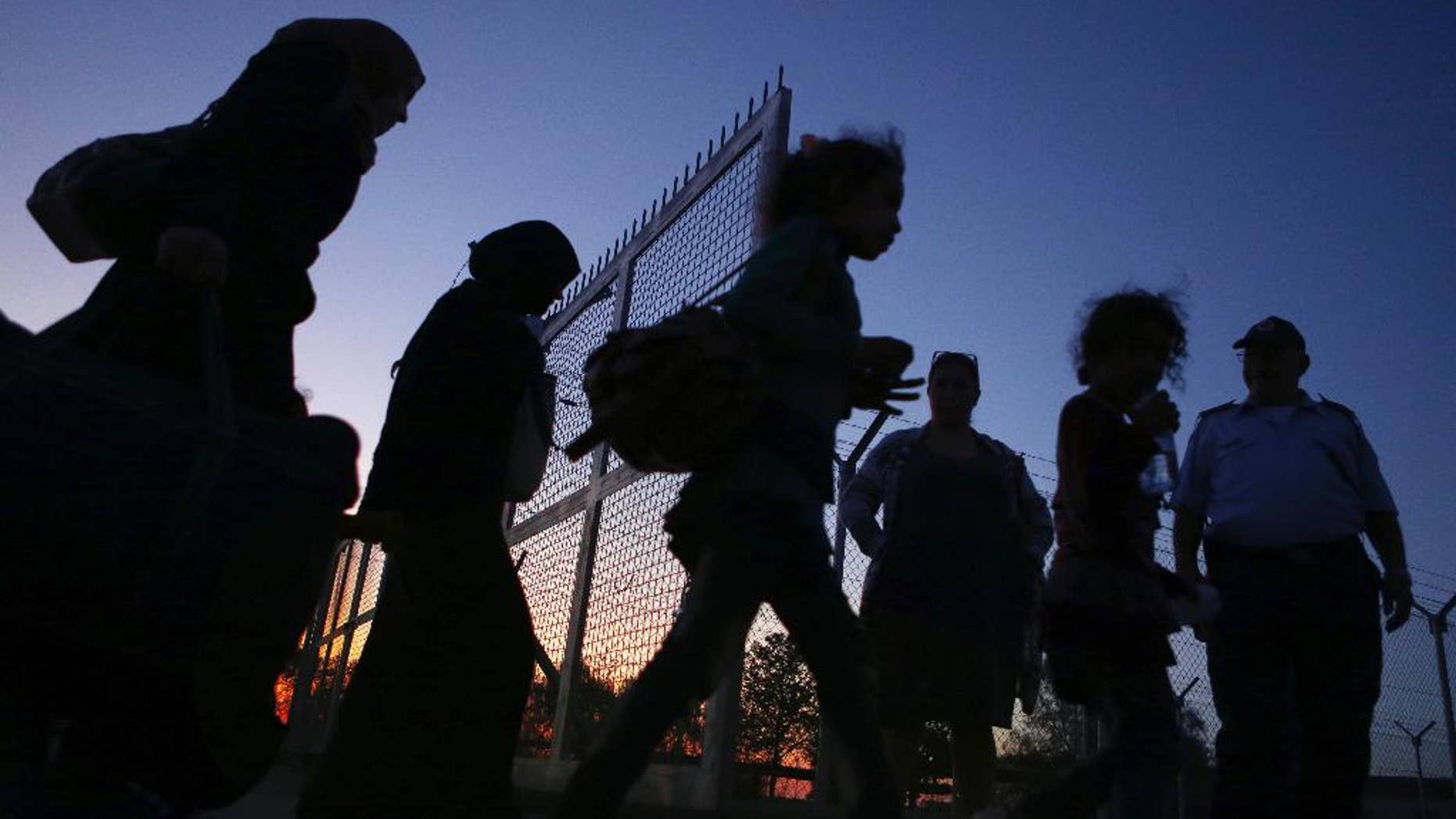 Migrants from Syria walk into a refugee camp in Kokkinotrimithia village outside the capital Nicosia, Cyprus, Friday, Oct. 21, 2016. A Cyprus police spokesman says a boat with 83 people aboard including 37 children has been towed to a harbor on the east Mediterranean island's northwestern coast. (AP Photo/Petros Karadjias)