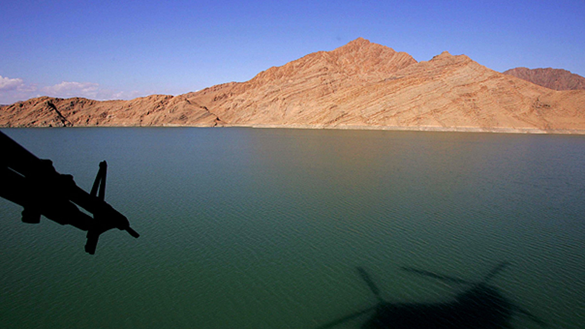 In this Jan. 11, 2007, file photo, a shadow of a British Royal Air Force Chinook helicopter is seen on the Kajaki Dam reservoir as it carries the supplies for the forward operating base at Kajaki, in southern Afghanistan.