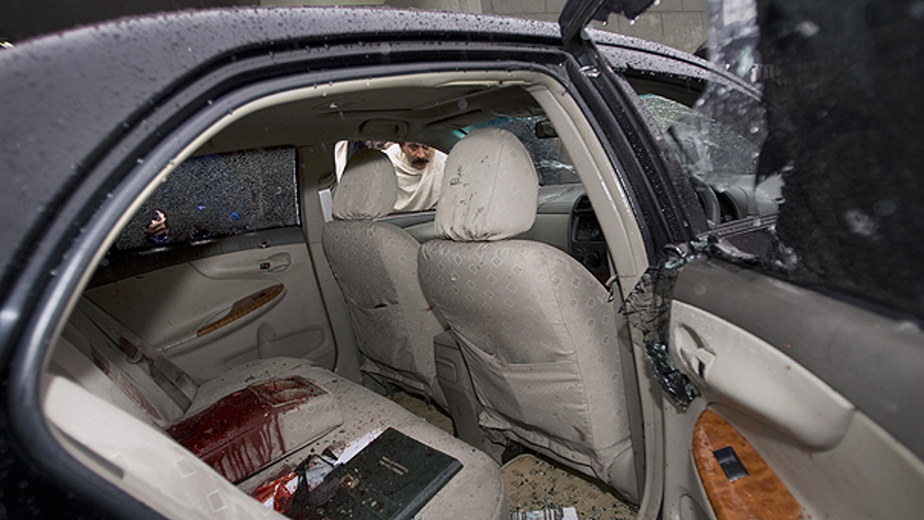 March 2: A Pakistani looks into the blood-stained damaged car of slain Pakistan's government minister for religious minorities Shahbaz Bhatti, outside emergency the ward of a local hospital in Islamabad, Pakistan.