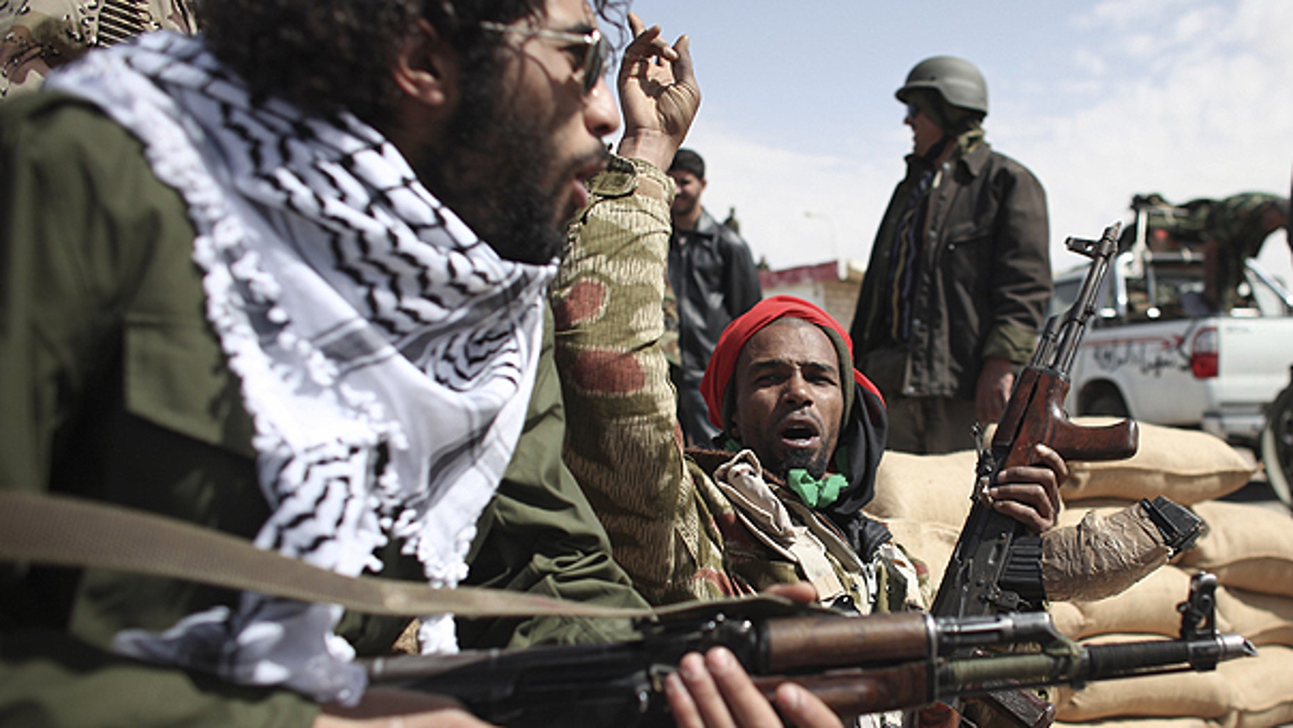 March 3: Defected Libyan soldiers and volunteers cheer as they sit on the outskirts of the eastern town of Brega, Libya.