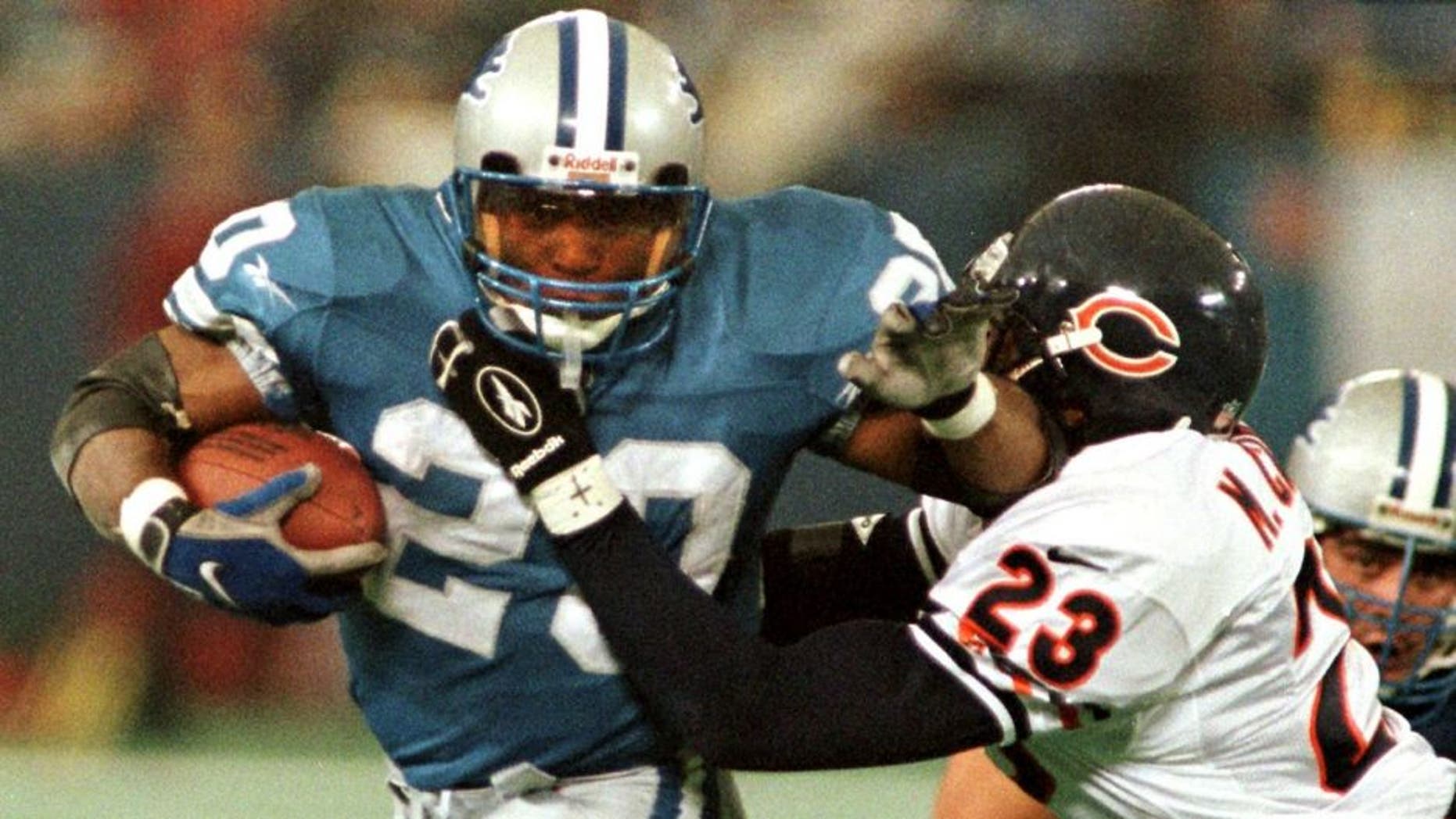 PONTIAC, : The Detroit Lions' Barry Sanders (L) brushes off Chicago Bears safety Marty Carter (R) on his way to the end zone for a touchdown in the third quarter, 27 November, at the Silverdome in Pontiac, MI. On the play, Sanders passed the 100-yard mark in a game for the 11th straight time tieing the NFL record held by Marcus Allen. The Lions beat the Bears 55-20. AFP PHOTO Matt CAMPBELL (Photo credit should read MATT CAMPBELL/AFP/Getty Images)