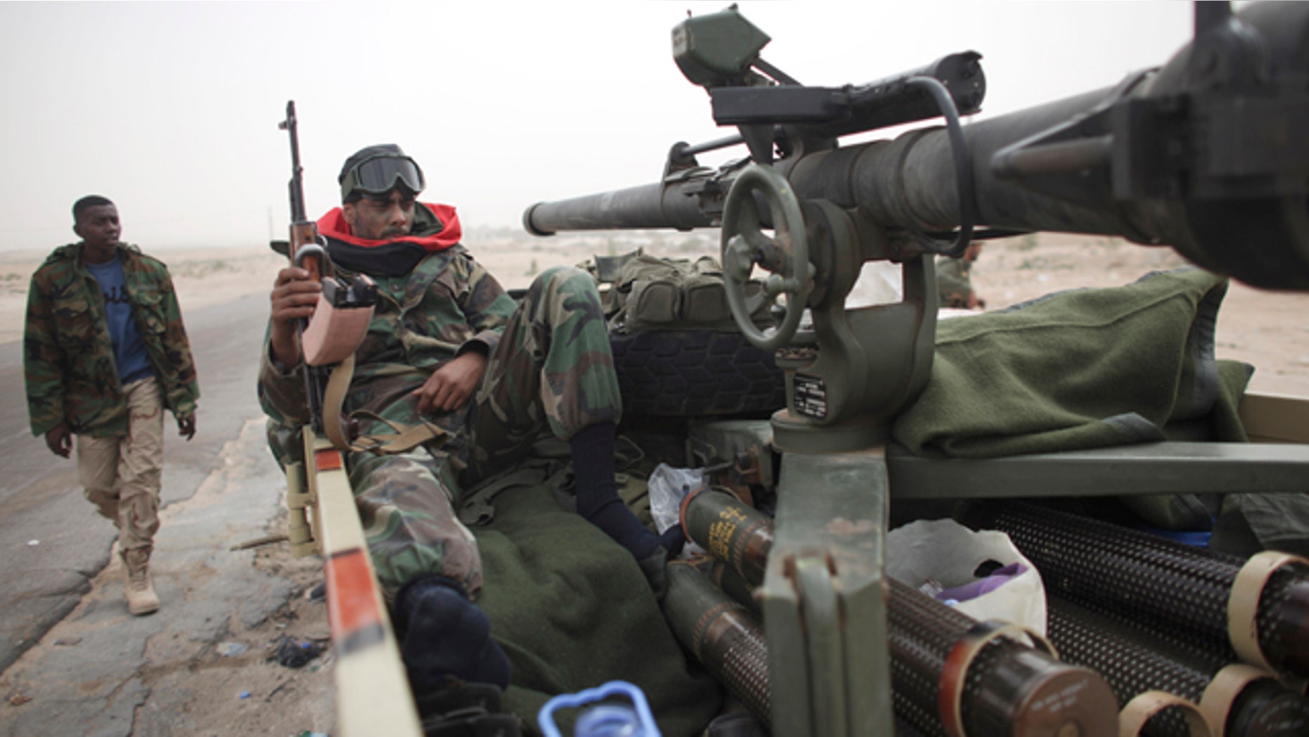 March 4: A defected Libyan soldier sits with his weapons on the outskirts of the eastern town of Brega, Libya.