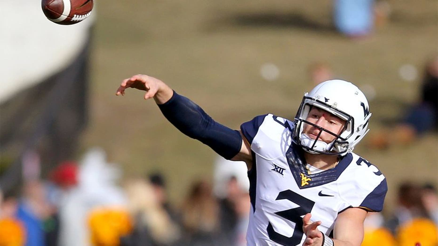Nov 29, 2014; Ames, IA, USA; West Virginia Mountaineers quarterback Skyler Howard (3) rolls out to pass against the Iowa State Cyclones at Jack Trice Stadium. Mandatory Credit: Reese Strickland-USA TODAY Sports