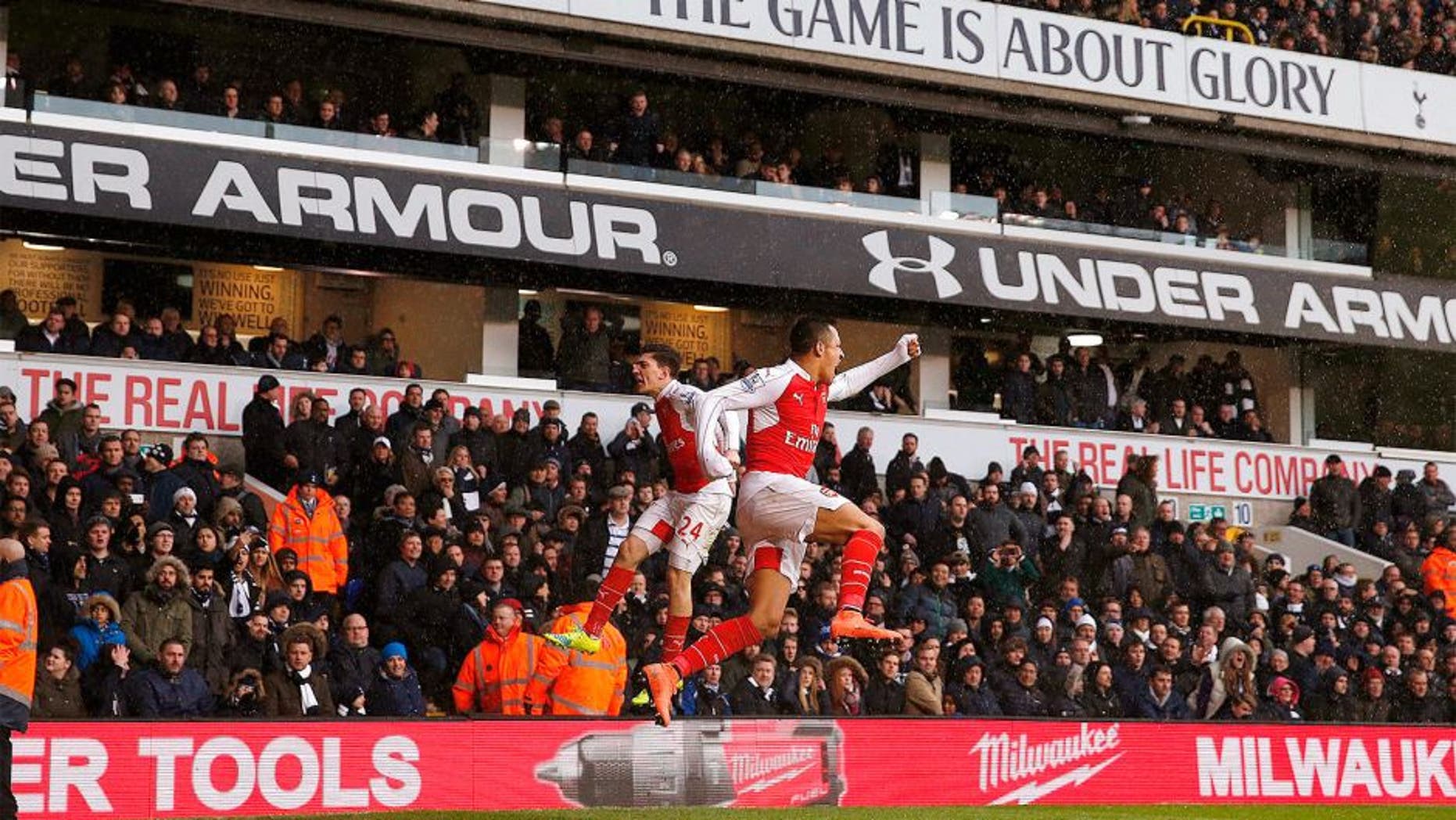 Arsenal's Chilean striker Alexis Sanchez (R) celebrates with Arsenal's Spanish defender Hector Bellerin (L) after scoring their second goal during the English Premier League football match between Tottenham Hotspur and Arsenal at White Hart Lane in London, on March 5, 2016. / AFP / ADRIAN DENNIS / RESTRICTED TO EDITORIAL USE. No use with unauthorized audio, video, data, fixture lists, club/league logos or 'live' services. Online in-match use limited to 75 images, no video emulation. No use in betting, games or single club/league/player publications. / (Photo credit should read ADRIAN DENNIS/AFP/Getty Images)