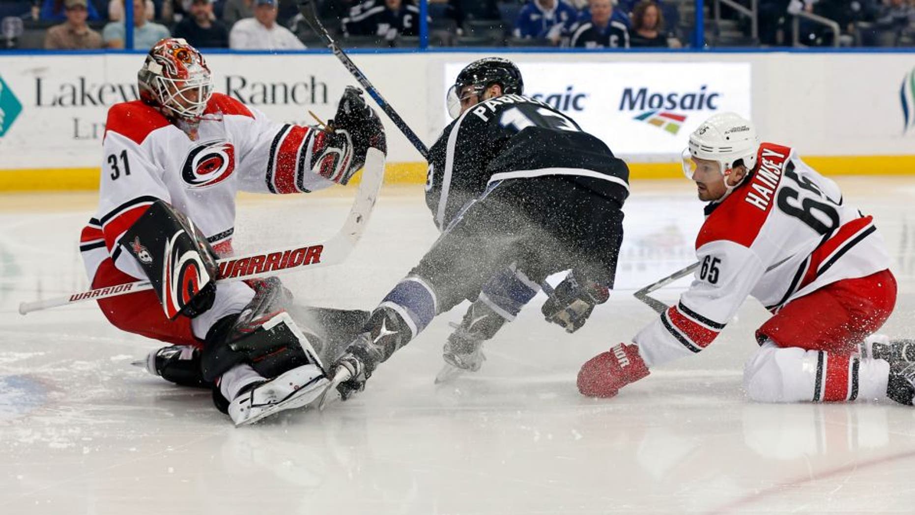 Carolina Hurricanes goalie Eddie Lack (31), of Sweden, makes a save on Tampa Bay Lightning's Cedric Paquette, as Hurricanes' Ron Hainsey defends during the second period of an NHL hockey game Saturday, March 5, 2016, in Tampa, Fla. (AP Photo/Mike Carlson)