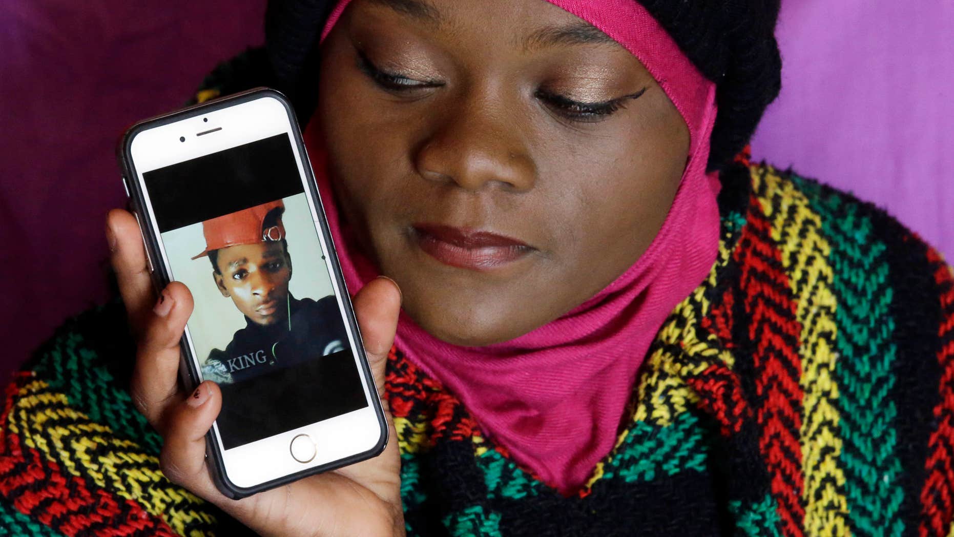 Abdi Mohamed's cousin Muslima Weledi holds a photograph of him during a interview Thursday, March 3, 2016, Salt Lake City.