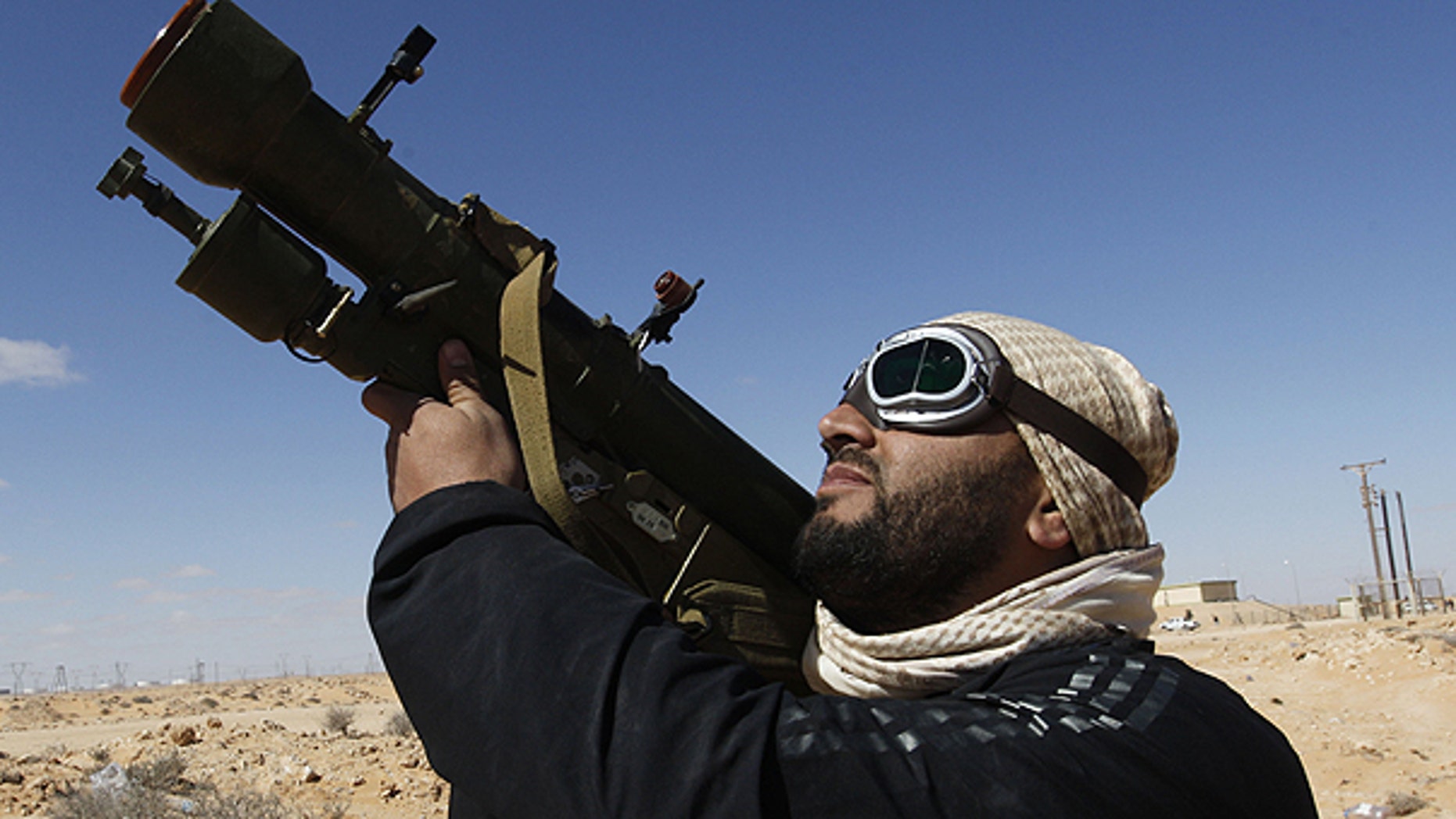 March 6: An rebel against Libyan leader Muammar Qaddafi holds his anti-aircraft missile as he looks to the sky, in the oil town of Ras Lanouf, eastern Libya.