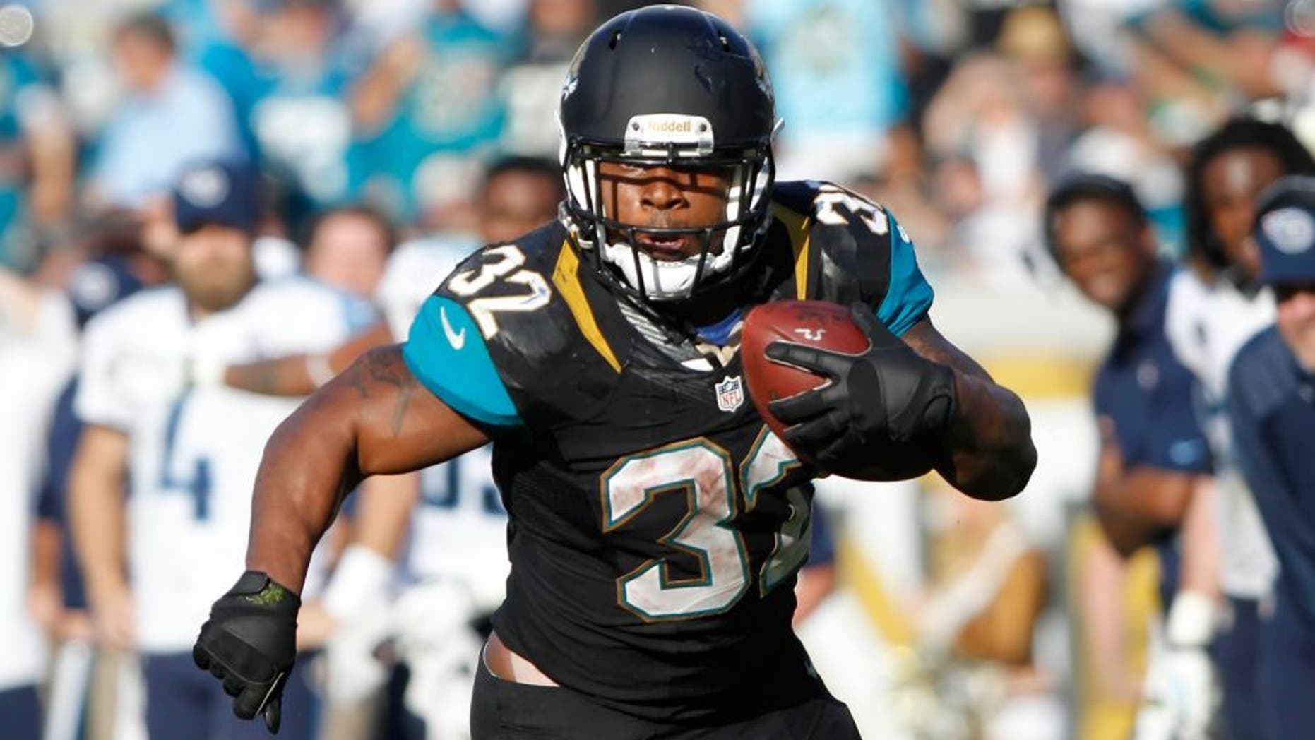 Dec 22, 2013; Jacksonville, FL, USA; Jacksonville Jaguars running back Maurice Jones-Drew (32) runs with the ball as Tennessee Titans defends during the second half at EverBank Field. Tennessee Titans defeated the Jacksonville Jaguars 20-16. Mandatory Credit: Kim Klement-USA TODAY Sports