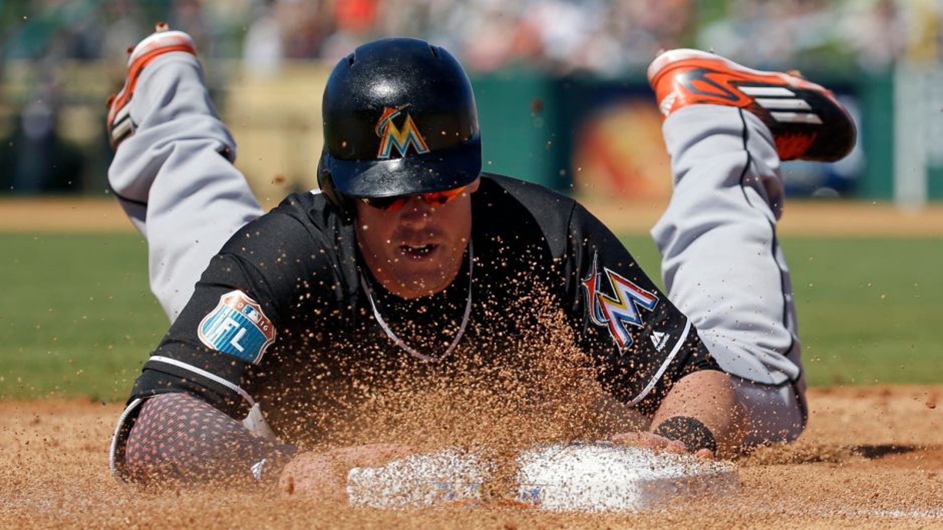 Miami Marlins' Justin Bour slides back to first base after an infield line drive was caught in the first inning of a spring training baseball game against the Detroit Tigers, Sunday, March 6, 2016, in Lakeland, Fla. (AP Photo/John Raoux)