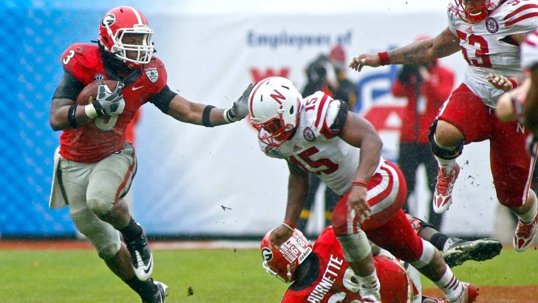 Jan 1, 2014; Jacksonville, FL, USA; Georgia Bulldogs tailback Todd Gurley (3) runs the ball against Nebraska Cornhuskers linebacker Michael Rose (15) as he runs for a first down in the fourth quarter of their game at EverBank Field. The Nebraska Cornhuskers beat the Georgia Bulldogs 24-19. Mandatory Credit: Phil Sears-USA TODAY Sports