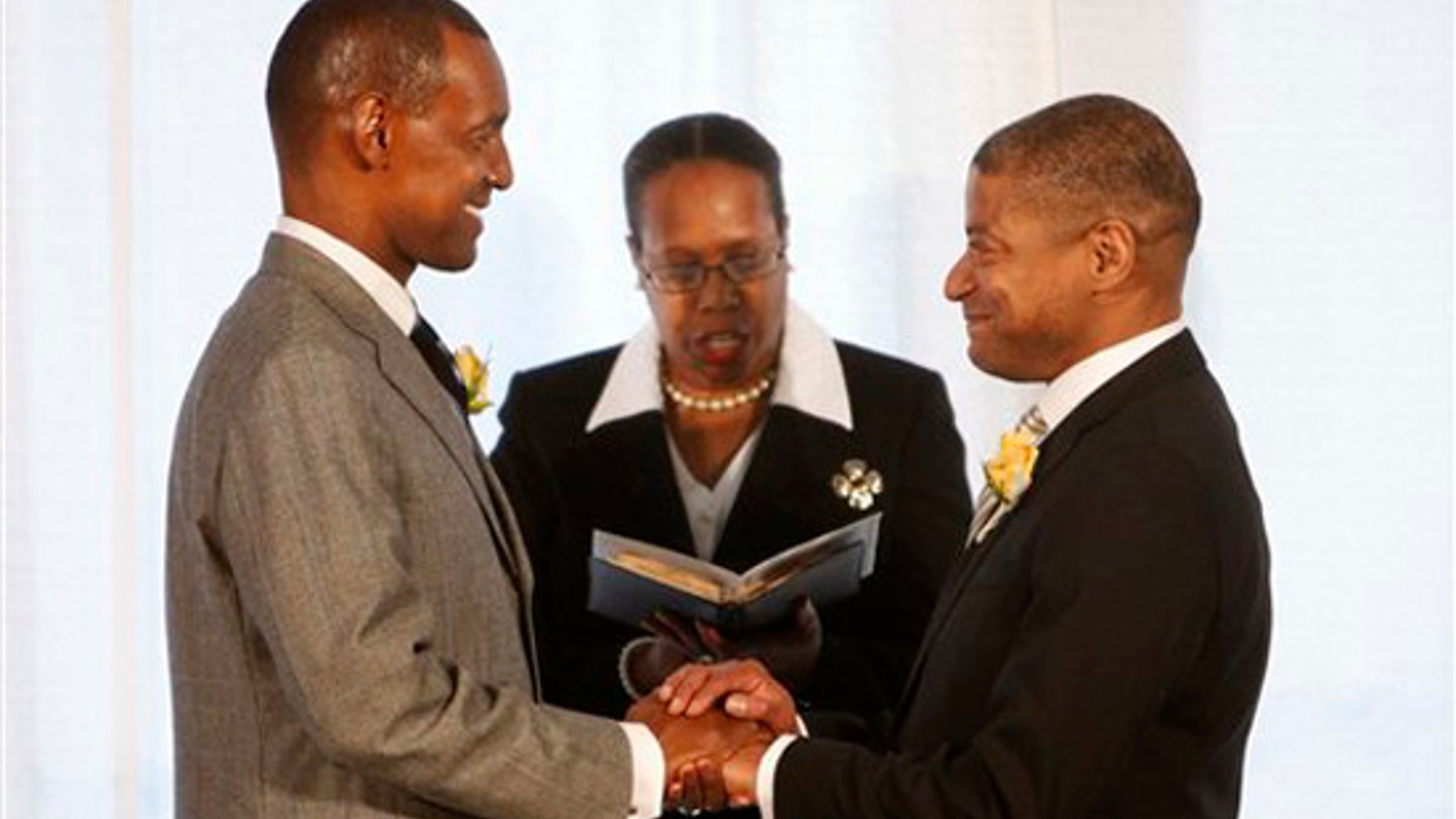 Rocky Galloway, left, and Reginald Stanley are pronounced "partners for life" by Rev. Sylvia E. Sumter during their marriage ceremony Tuesday, March 9, 2010, the first day that gay marriage is legal in Washington. (AP)