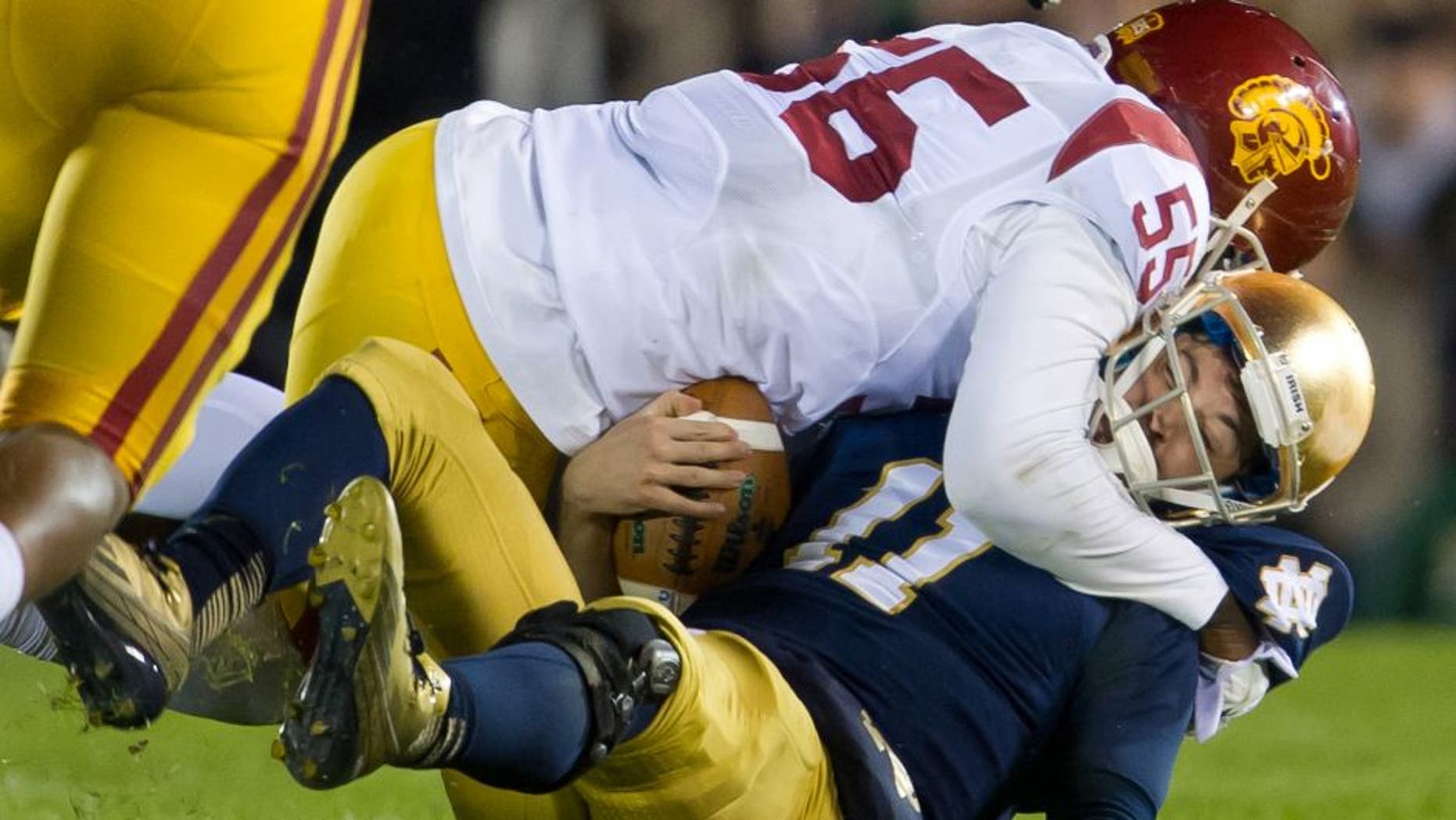 Oct 19, 2013; South Bend, IN, USA; Notre Dame Fighting Irish quarterback Tommy Rees (11) is sacked by USC Trojans linebacker Lamar Dawson (55) in the third quarter at Notre Dame Stadium. Notre Dame won 14-10. Mandatory Credit: Matt Cashore-USA TODAY Sports