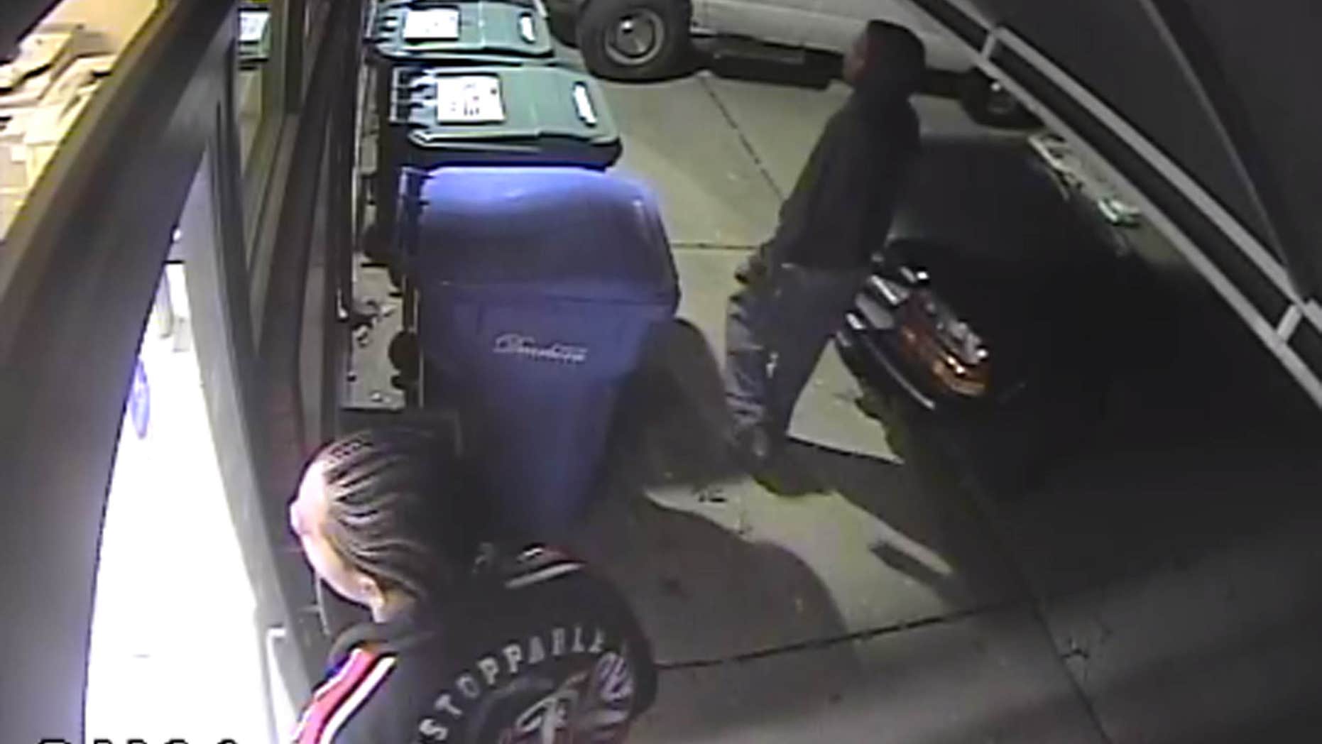 This photo from video surveillance provided by the Dearborn Police Department shows two men trying to break into the Detroit-area offices of The Arab American News as employees worked to publish the newspaper.