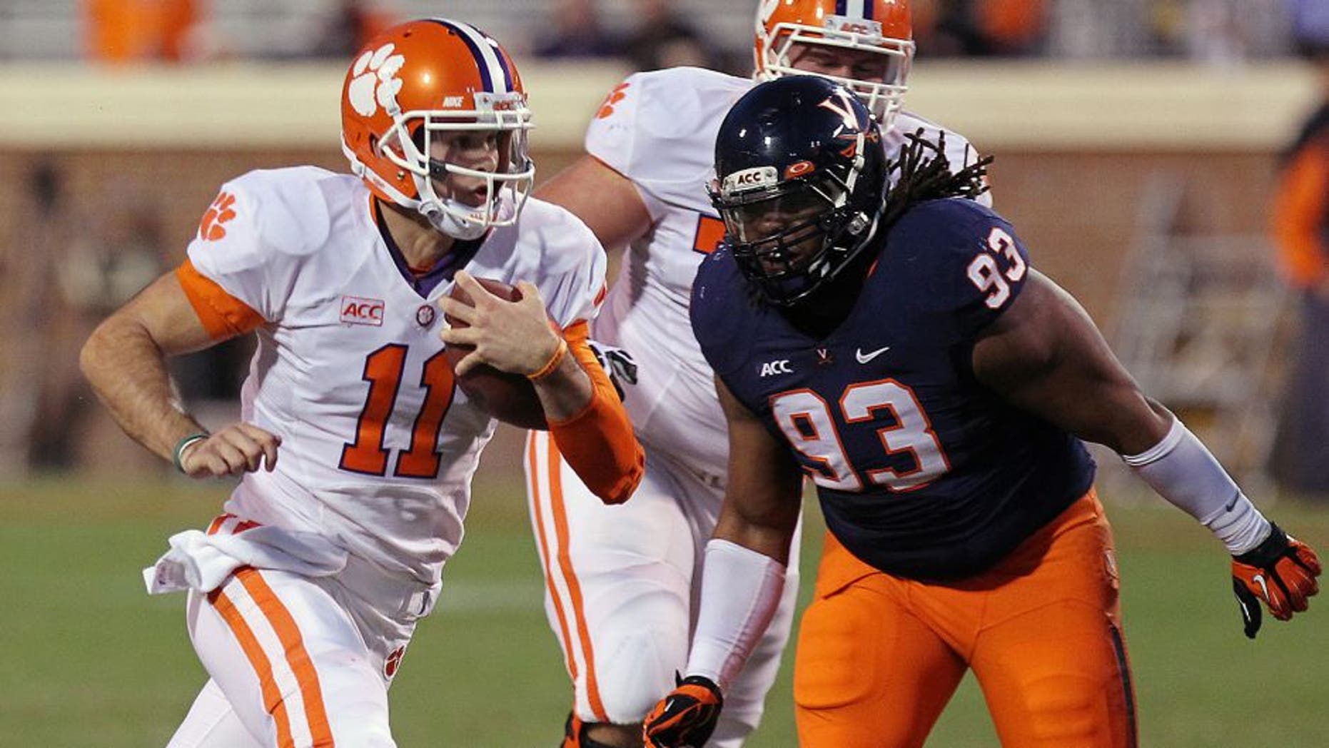 Nov 2, 2013; Charlottesville, VA, USA; Clemson Tigers quarterback Chad Kelly (11) runs with the ball past Virginia Cavaliers defensive tackle Donte Wilkins (93) to score a touchdown in the fourth quarter at Scott Stadium. The Tigers won 59-10. Mandatory Credit: Geoff Burke-USA TODAY Sports