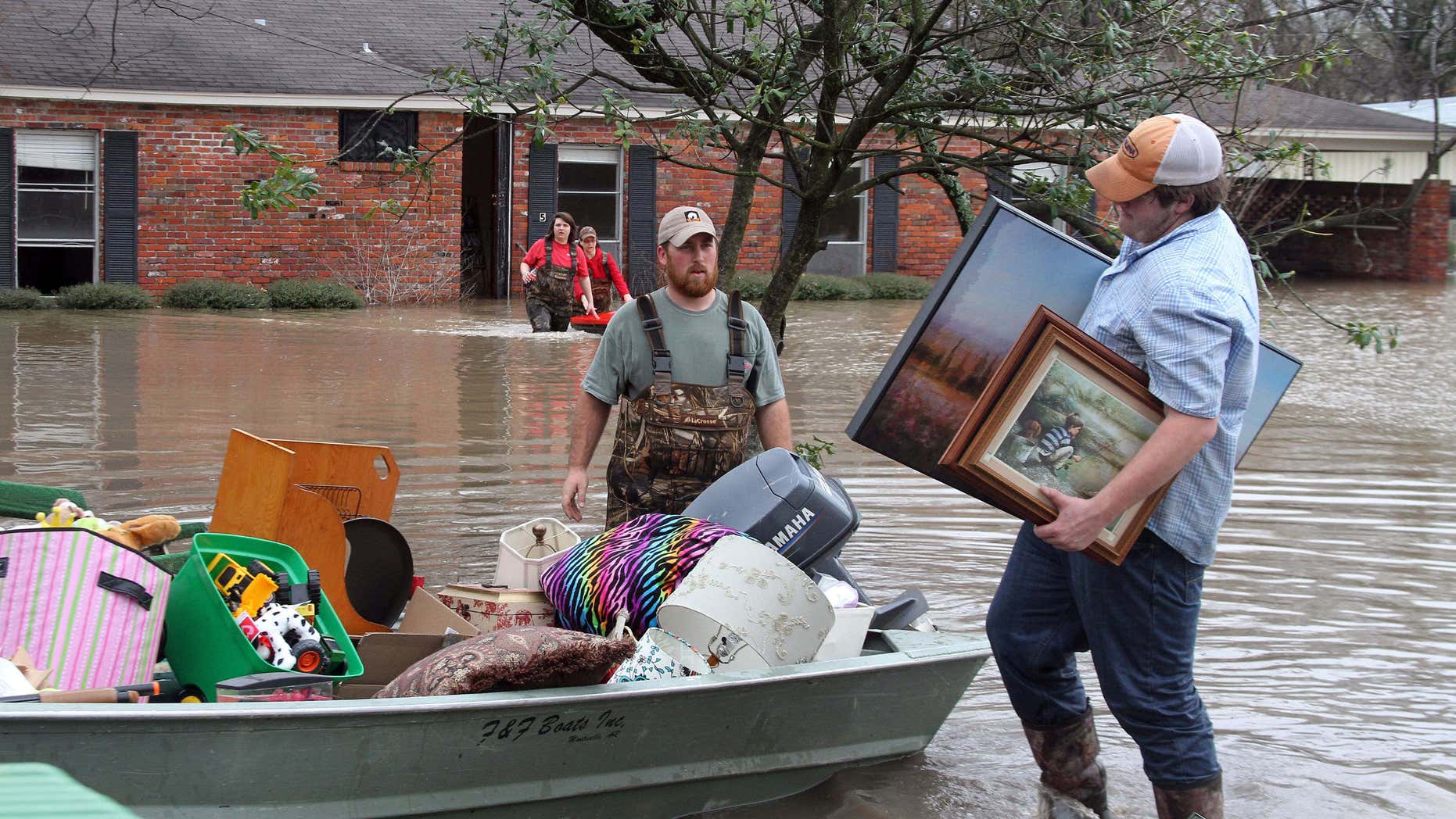 Volunteers return to a flooded house in Clarksdale, Miss., Friday, March 11, 2016, to assist the owners retrieve personal items as flood waters continued to rise following another morning of rain.