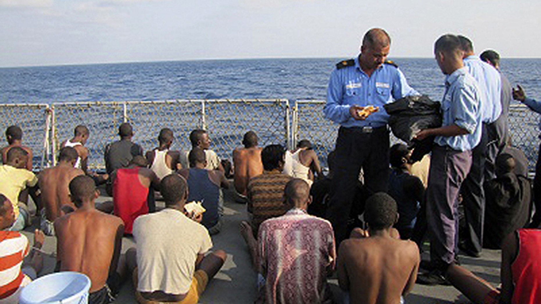 March 13: In this photo released by the Government of India Press Information Bureau, Indian naval officers distribute food to the captured pirates aboard an Indian naval ship in the Arabian Sea, off the coast of Kochi, India.