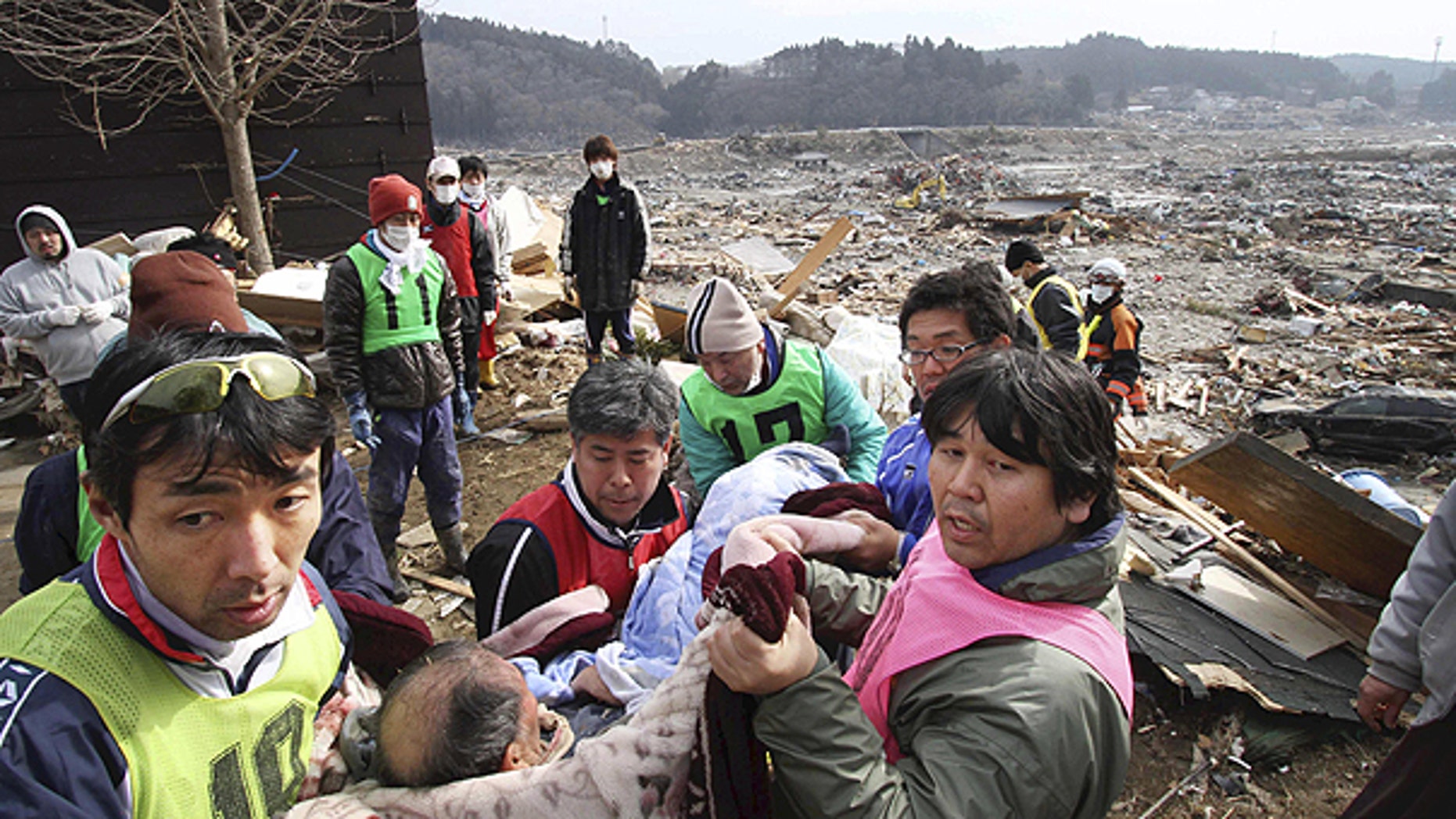 March 14: Rescue workers carry an elderly man found alive by tsunami survivors buried under rubble along a slope of a hill in n Minami Sanrikucho in Iwate Prefecture three days after a powerful earthquake-triggered tsunami hit the country's east coast.