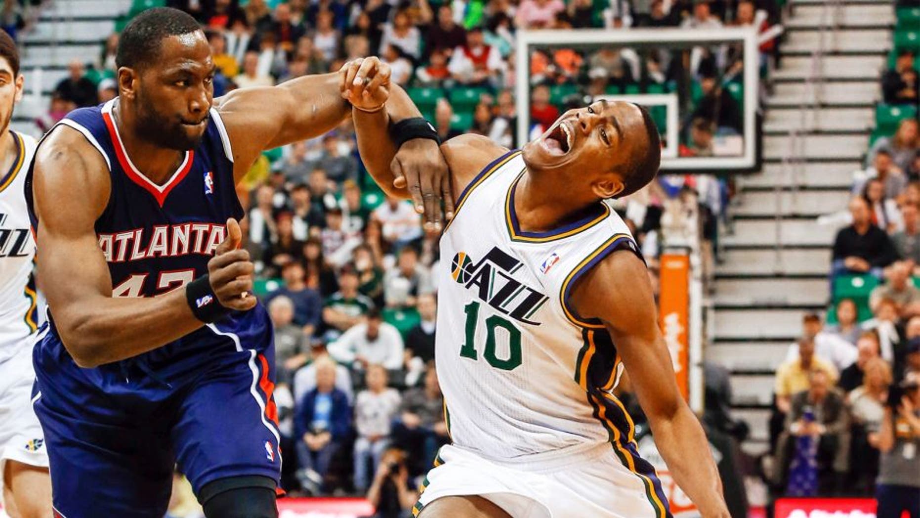 Mar 10, 2014; Salt Lake City, UT, USA; Utah Jazz point guard Alec Burks (10) is fouled by Atlanta Hawks power forward Elton Brand (42) during the third quarter at EnergySolutions Arena. The Atlanta Hawks won the game 112-110. Mandatory Credit: Chris Nicoll-USA TODAY Sports