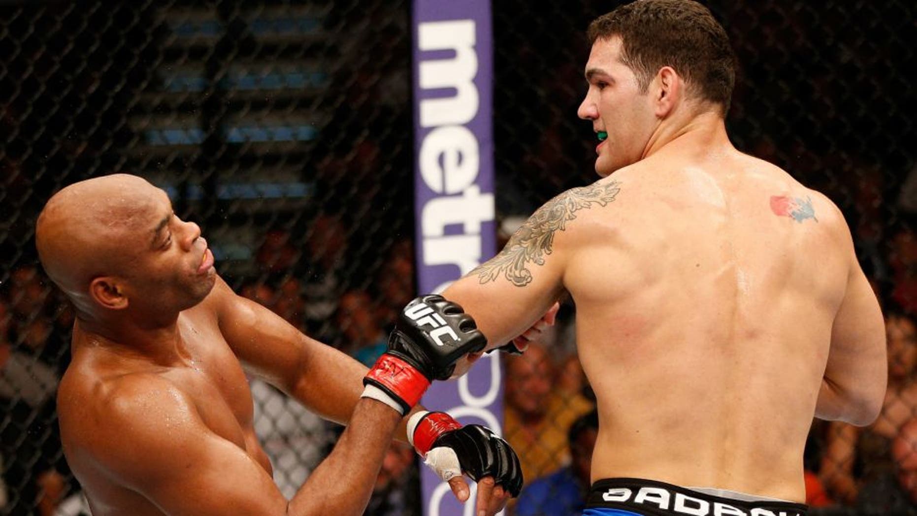 LAS VEGAS, NV - JULY 06: (R-L) Chris Weidman looks on as Anderson Silva falls to the canvas after a punch in their UFC middleweight championship fight during the UFC 162 event inside the MGM Grand Garden Arena on July 6, 2013 in Las Vegas, Nevada. (Photo by Josh Hedges/Zuffa LLC/Zuffa LLC via Getty Images) *** Local Caption *** Anderson Silva; Chris Weidman