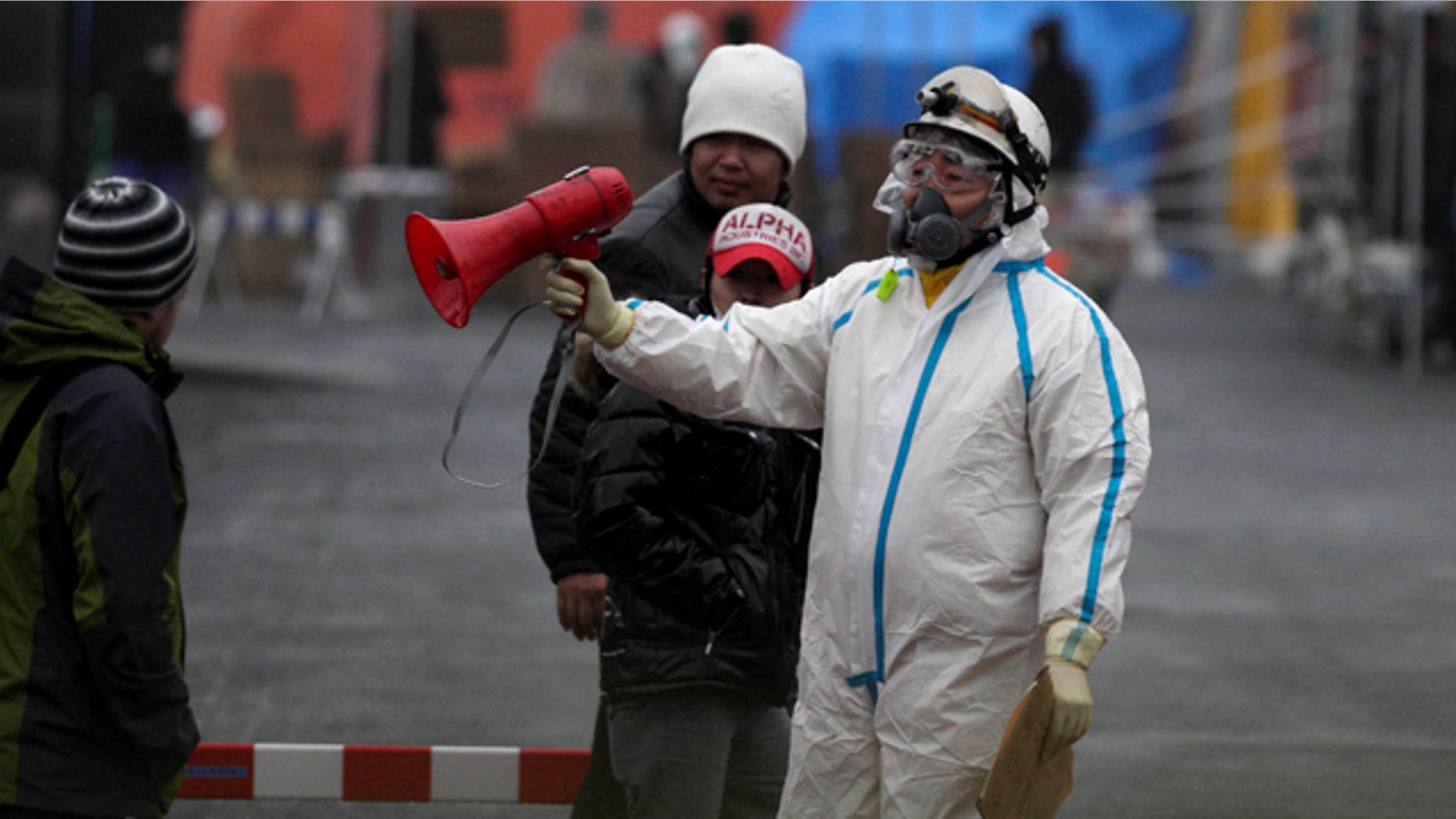 March 15: Officials wearing clothing to protect against radiation directs people to a center to scan residents who have been within 20 kilometers of the Fukushima Dai-ichi nuclear plant damaged by Friday's earthquake in Koriyama, Fukushima Prefecture, Japan.