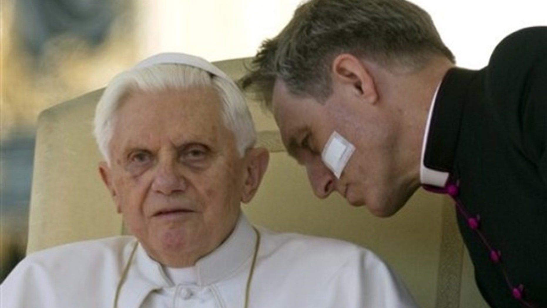 Pope Benedict XVI listens to his personal secretary Georg Gaenswein during a general audience in St. Peter's square at the Vatican, Wednesday, March 17, 2010. (AP)