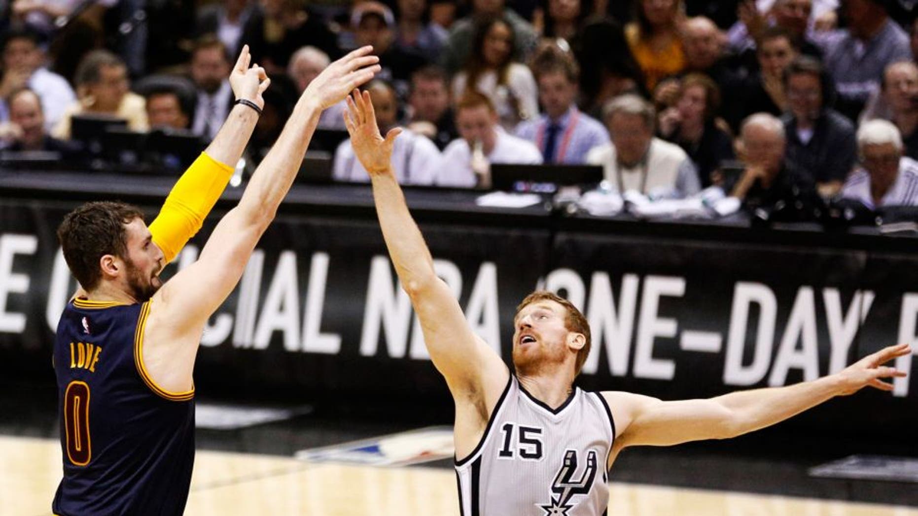 Mar 12, 2015; San Antonio, TX, USA; Cleveland Cavaliers forward Kevin Love (0) shoots the ball over San Antonio Spurs power forward Matt Bonner (15) during the first half at AT&T Center. Mandatory Credit: Soobum Im-USA TODAY Sports