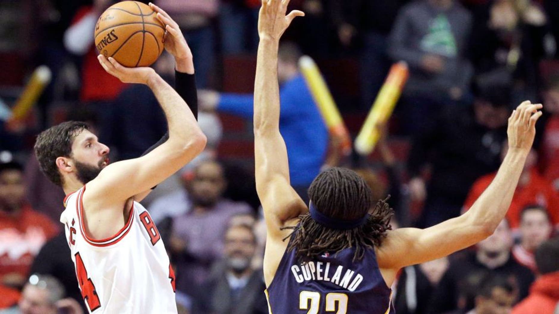 Chicago Bulls forward Nikola Mirotic, left, shoots over Indiana Pacers forward Chris Copeland during the second half of an NBA basketball game in Chicago on Wednesday, March 18, 2015. The Bulls won 103-86. (AP Photo/Nam Y. Huh)
